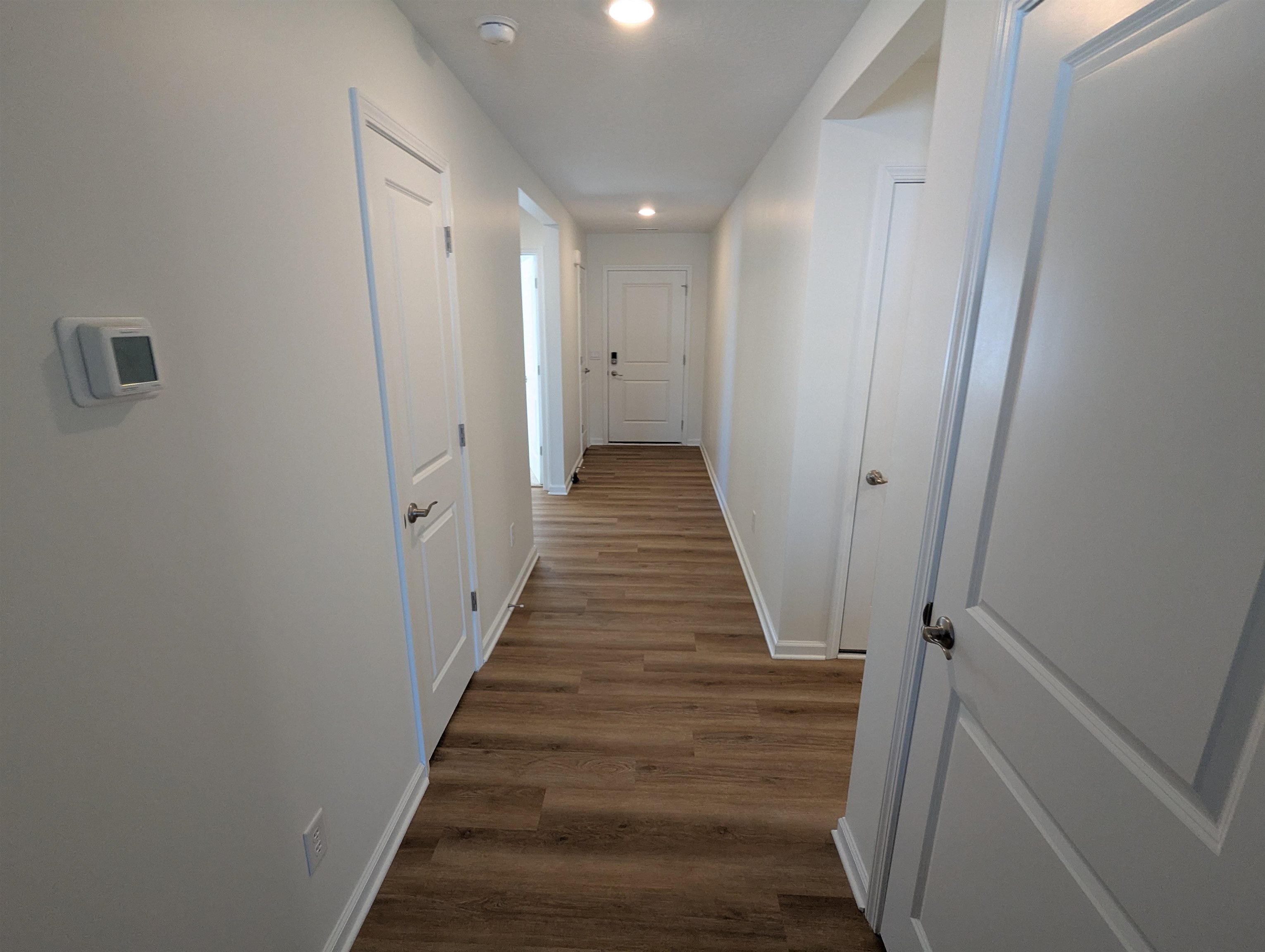 Hall with dark wood-style floors and recessed lighting