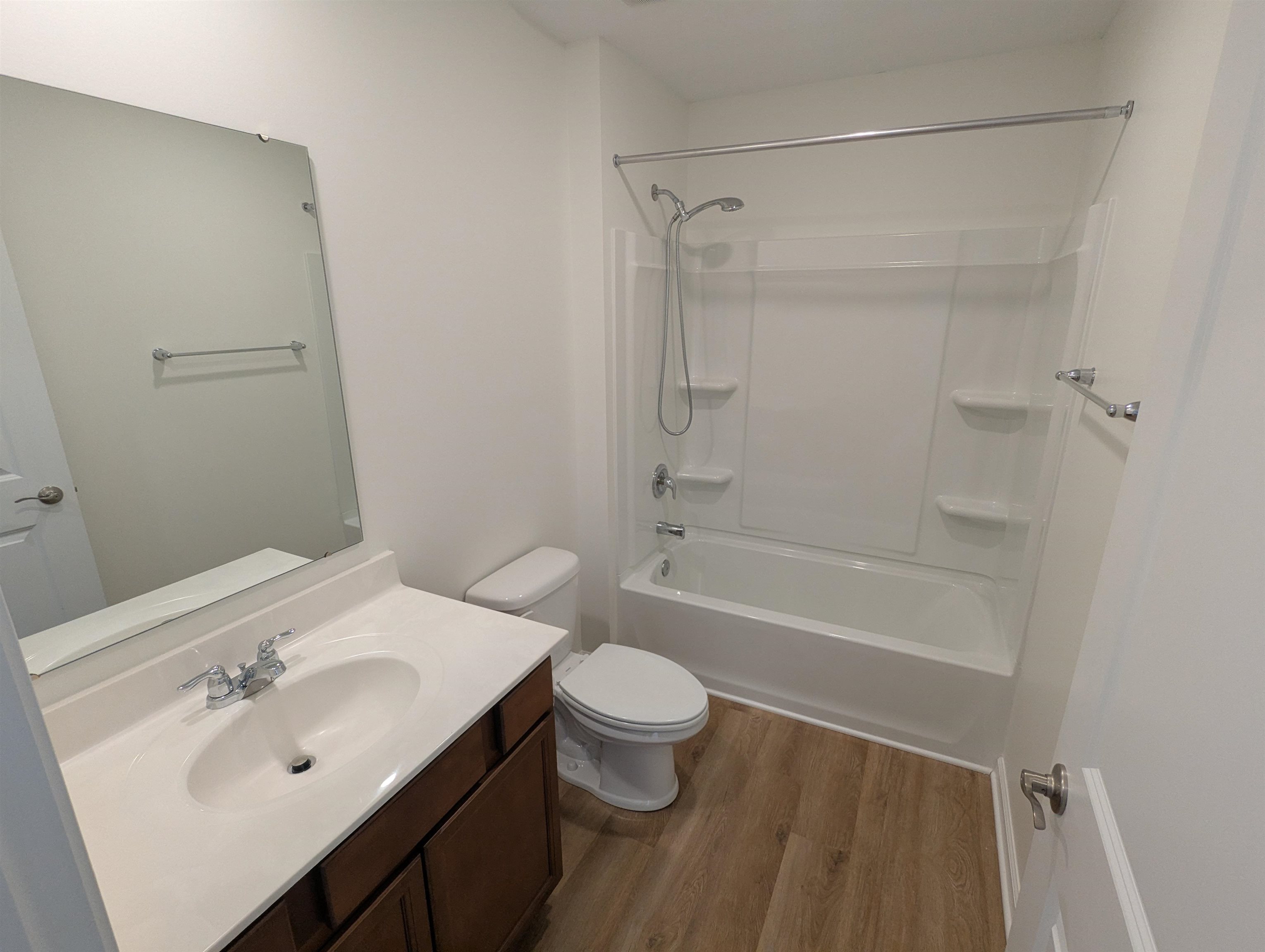 Full bathroom with vanity, light wood-style floors, and shower / tub combination