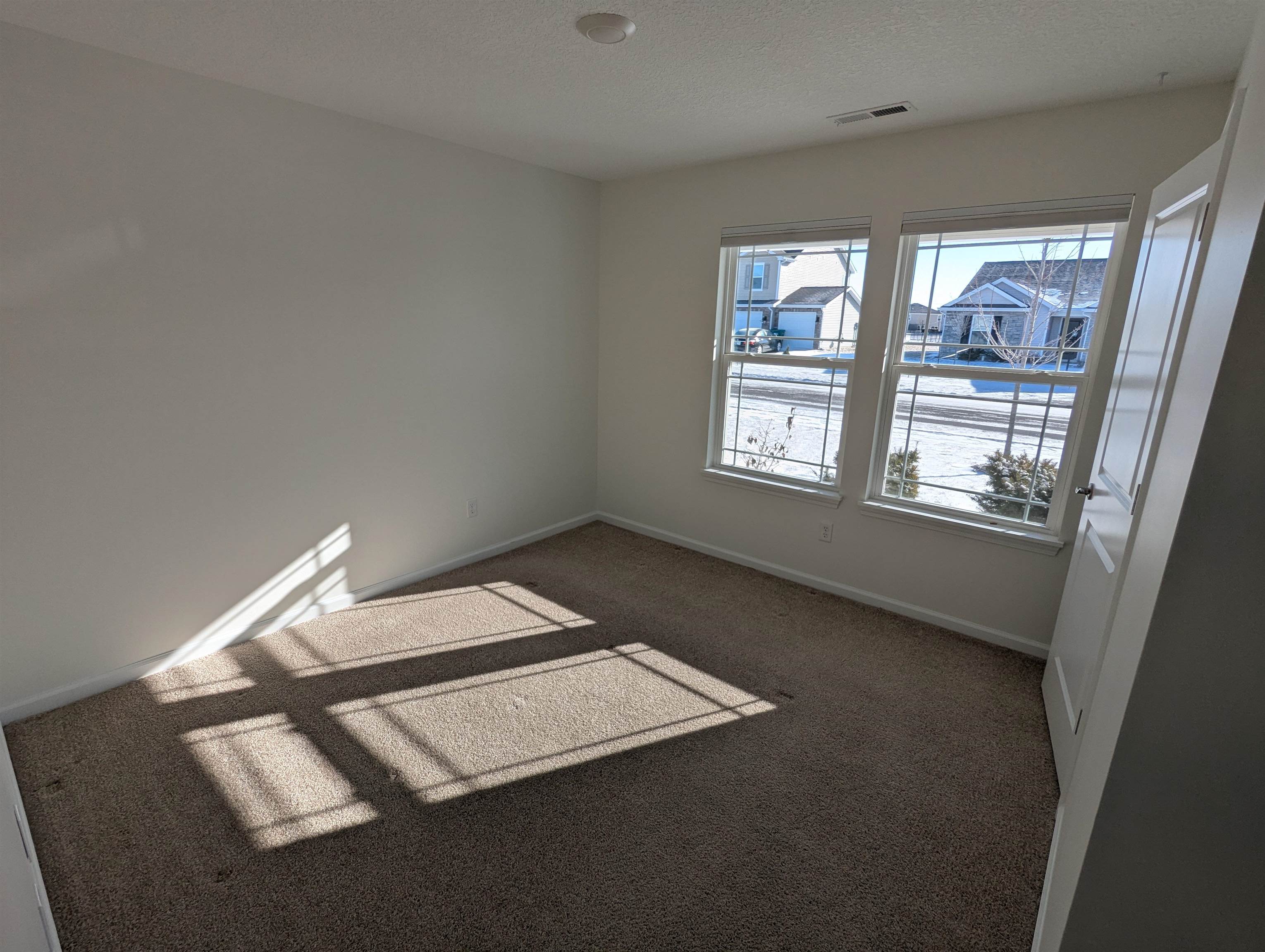 Spare room featuring carpet flooring and a textured ceiling