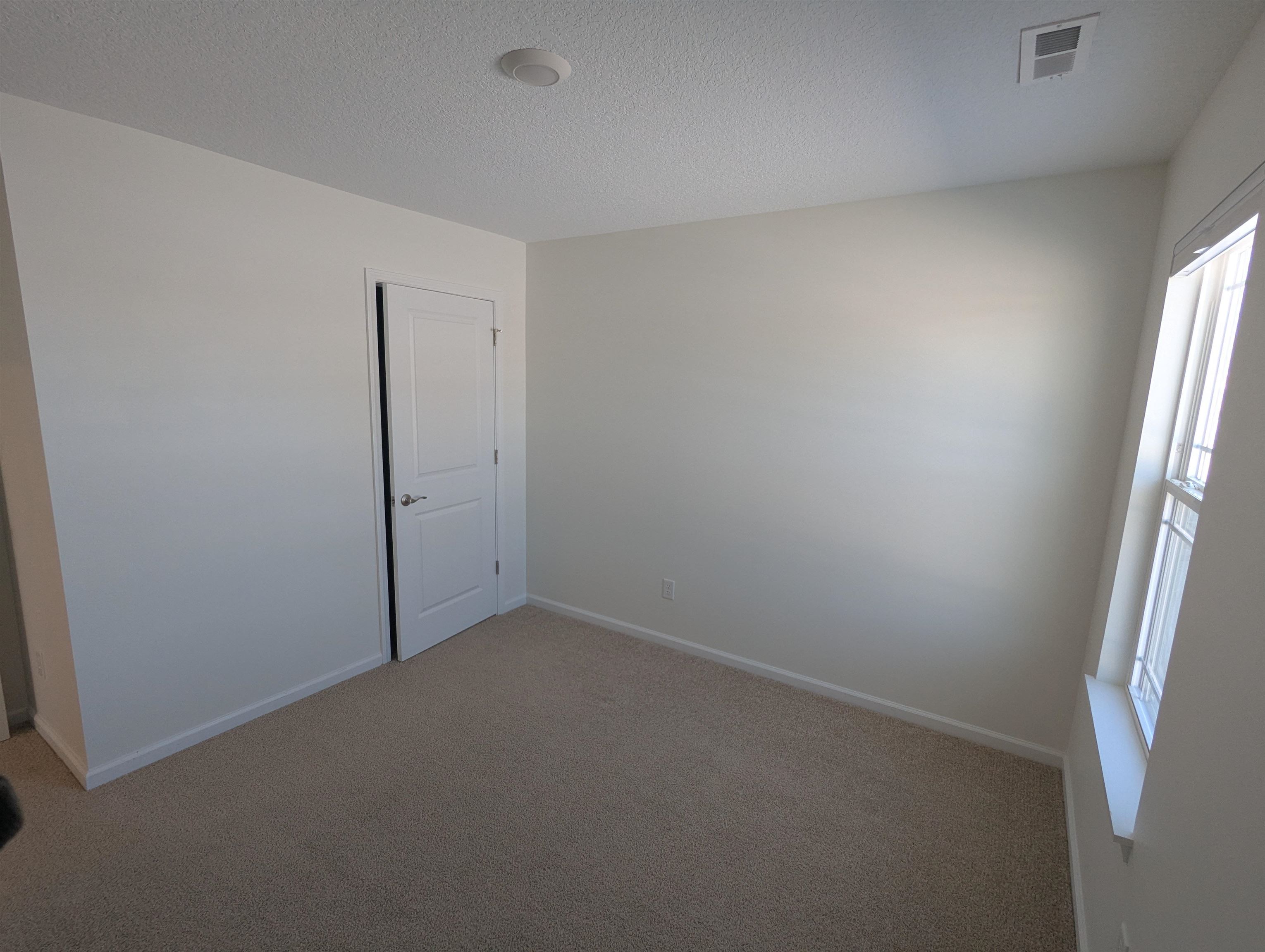 Spare room featuring carpet flooring and a textured ceiling