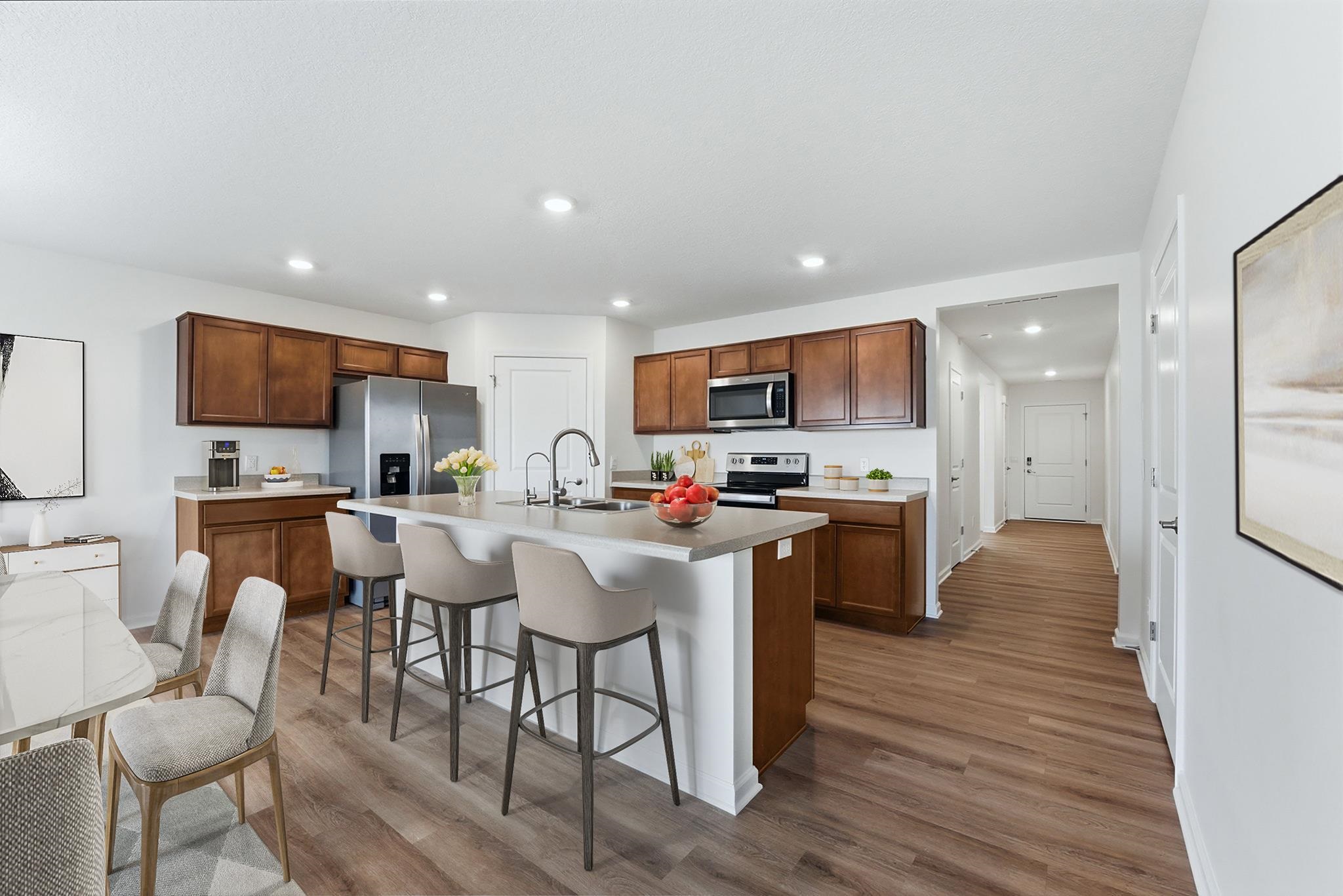 Kitchen featuring a kitchen bar, a center island with sink, light wood-style floors, light countertops, and recessed lighting