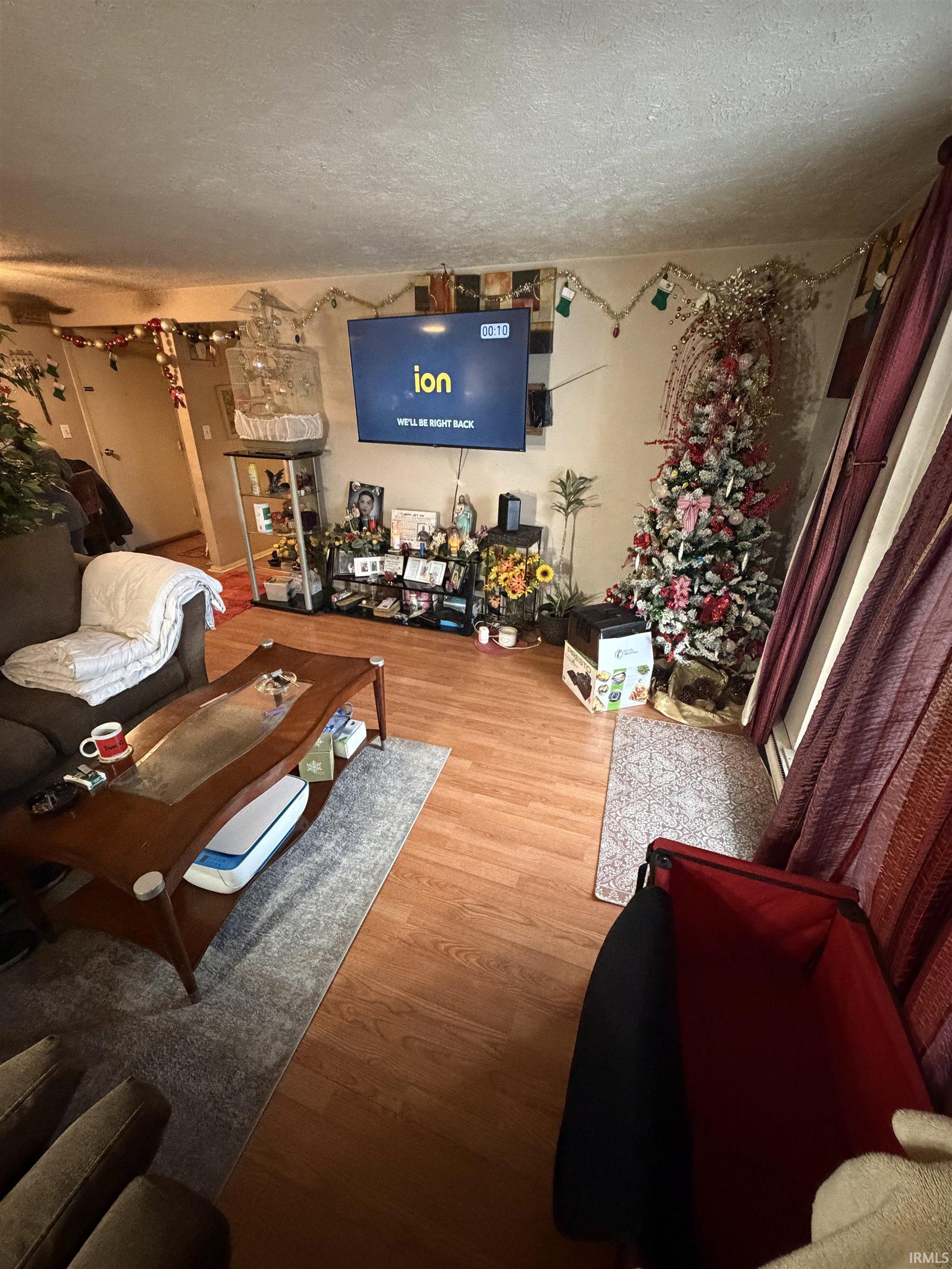Living area featuring a textured ceiling and wood finished floors
