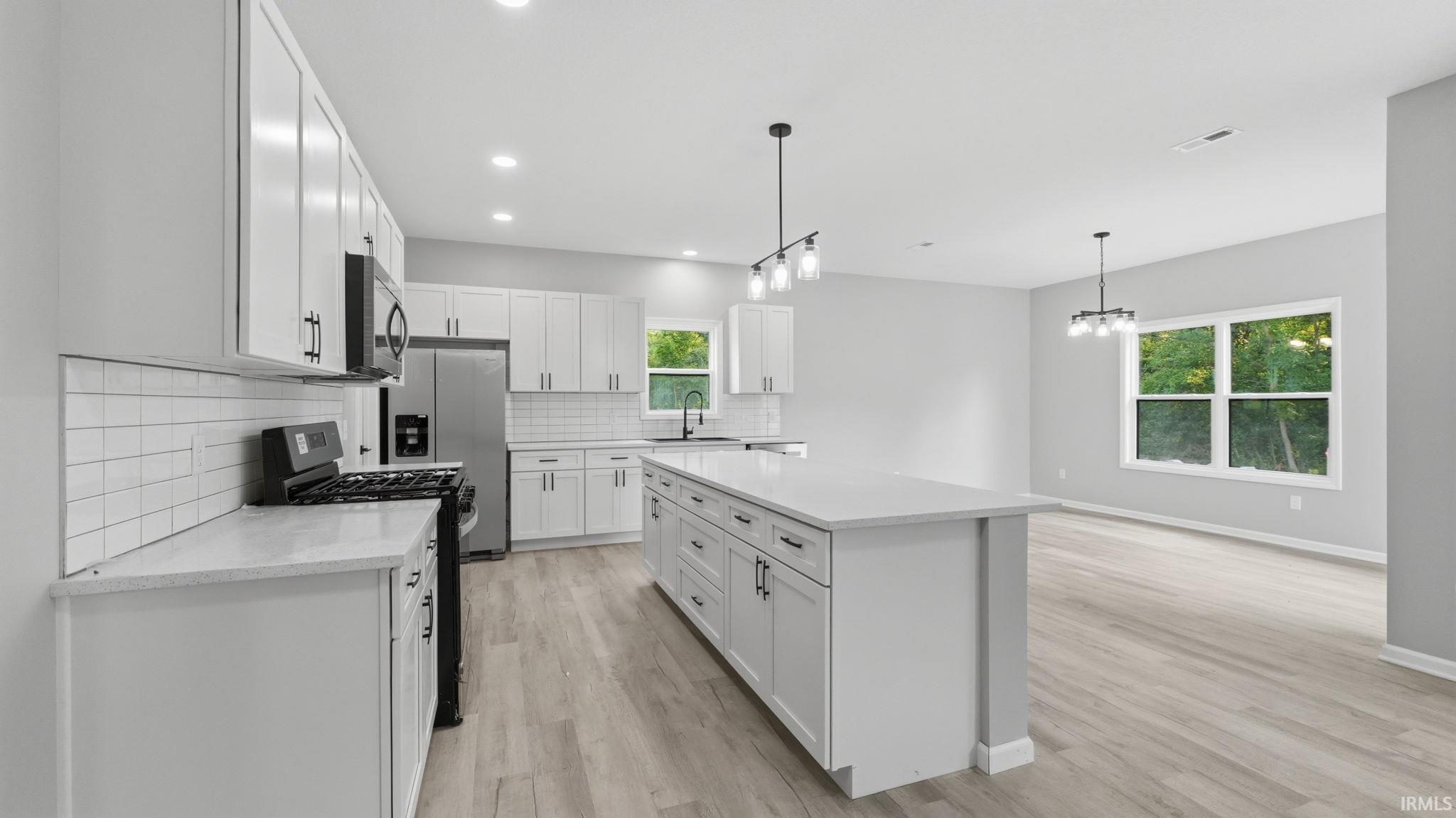Open-concept living area with light wood-finish flooring