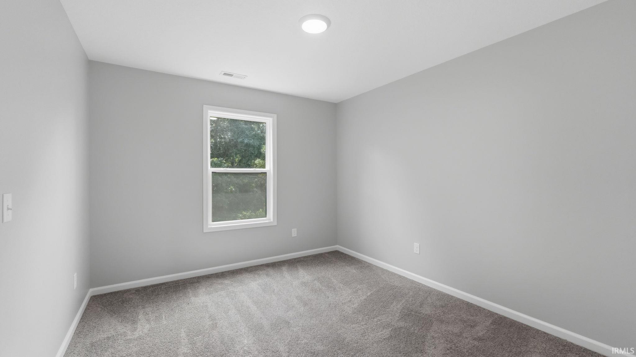 Room featuring light gray walls, white trim, and gray carpet flooring