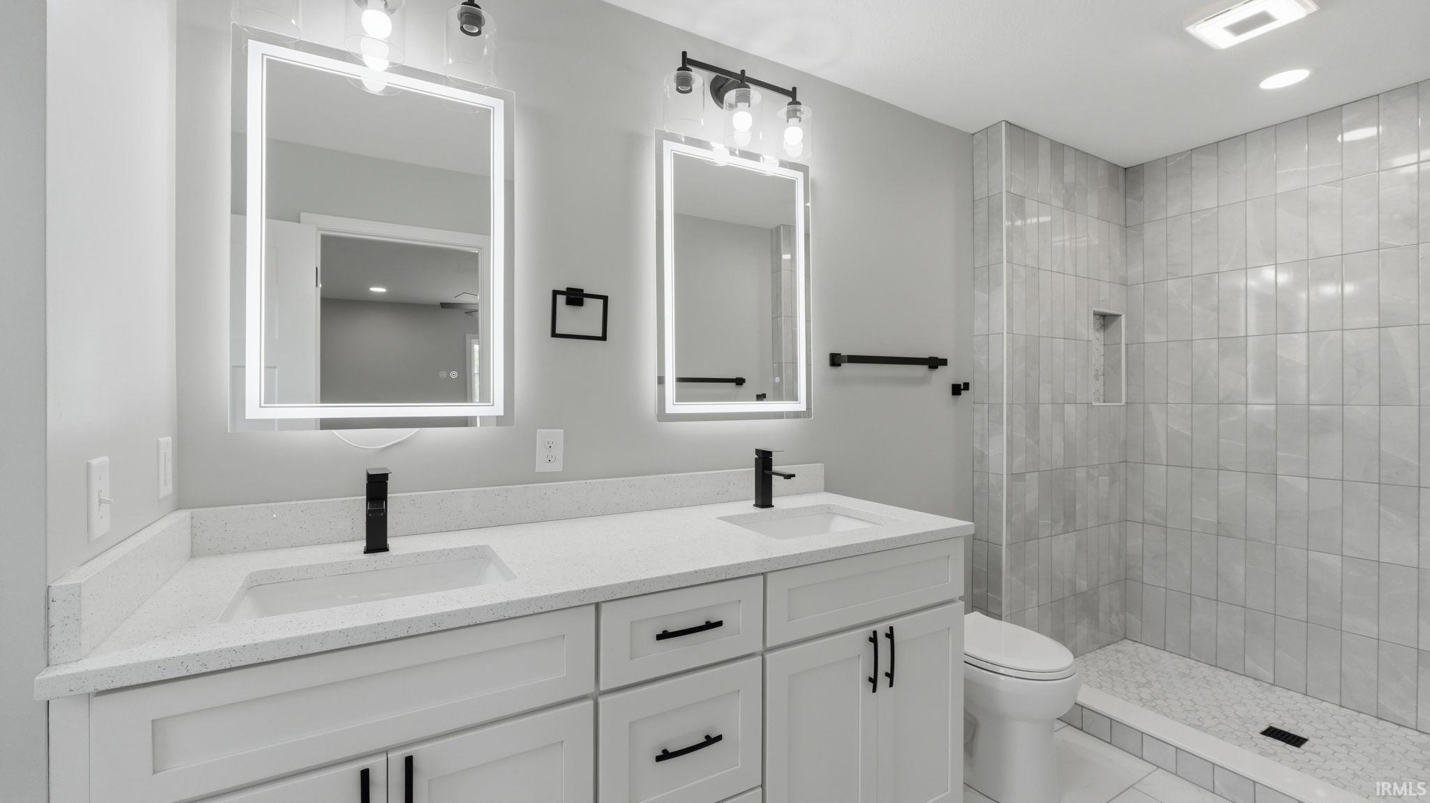 Dual vanity with white cabinetry, integrated sinks, and quartz countertops