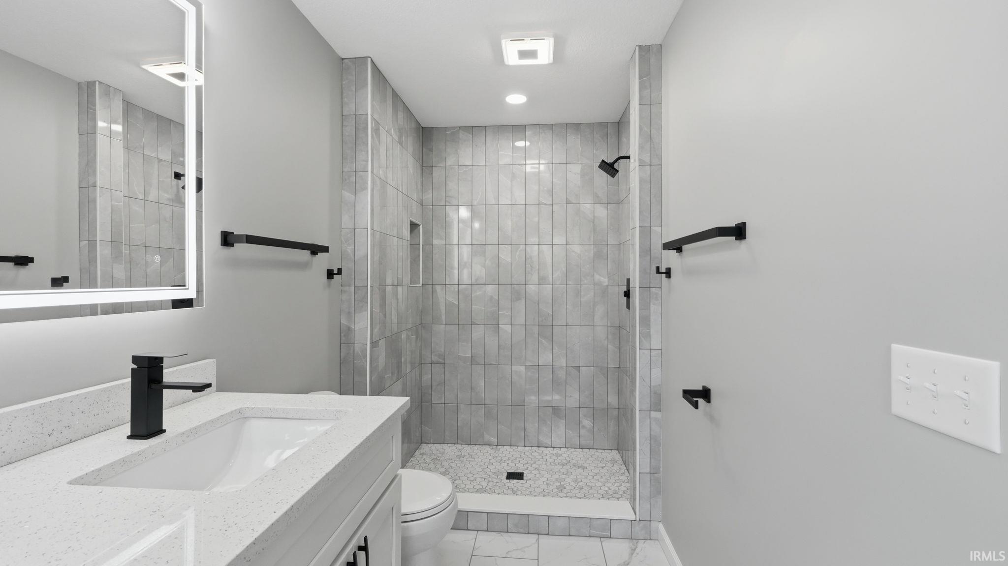 Shower with vertical tile walls and a mosaic floor