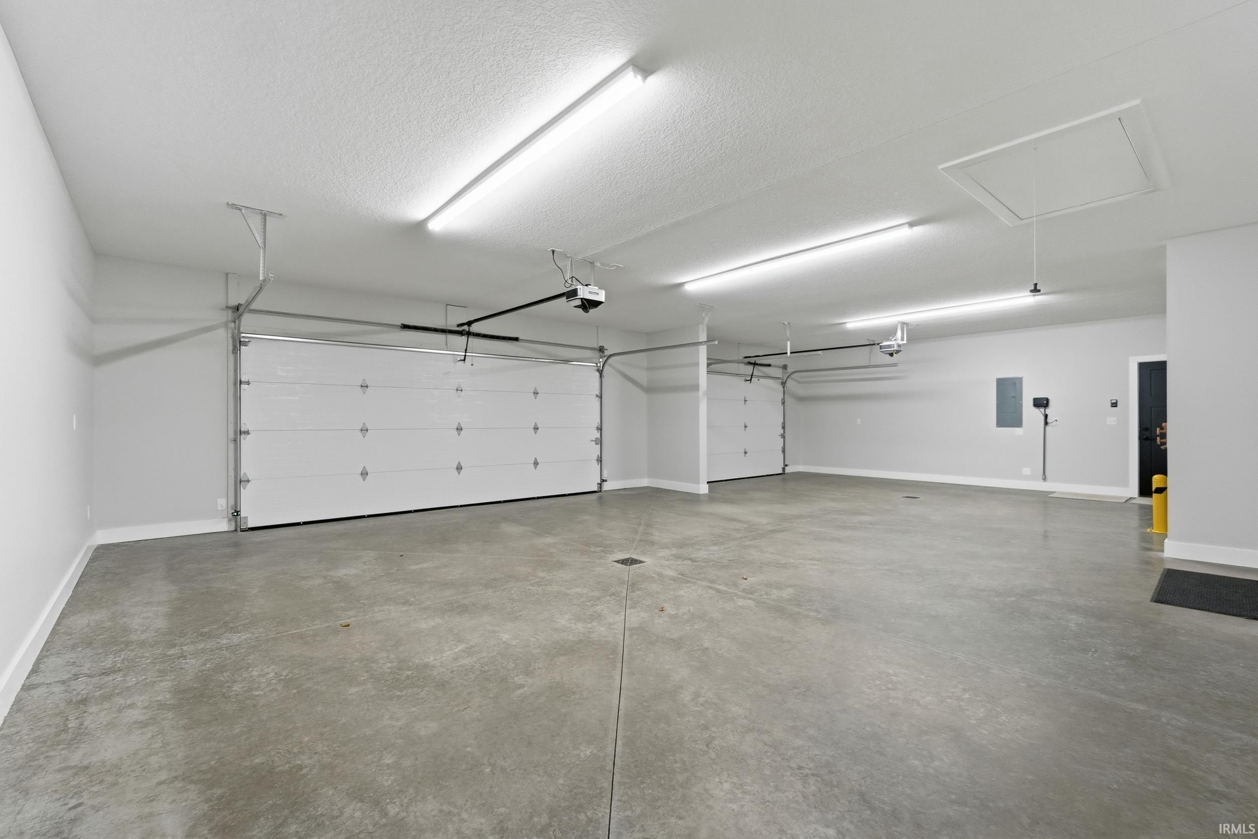 Garage featuring baseboards and electric panel