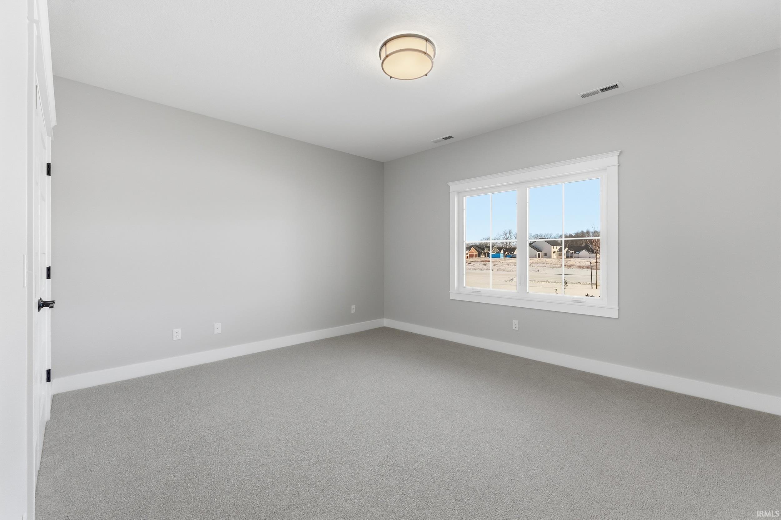 Unfurnished room featuring baseboards and light colored carpet