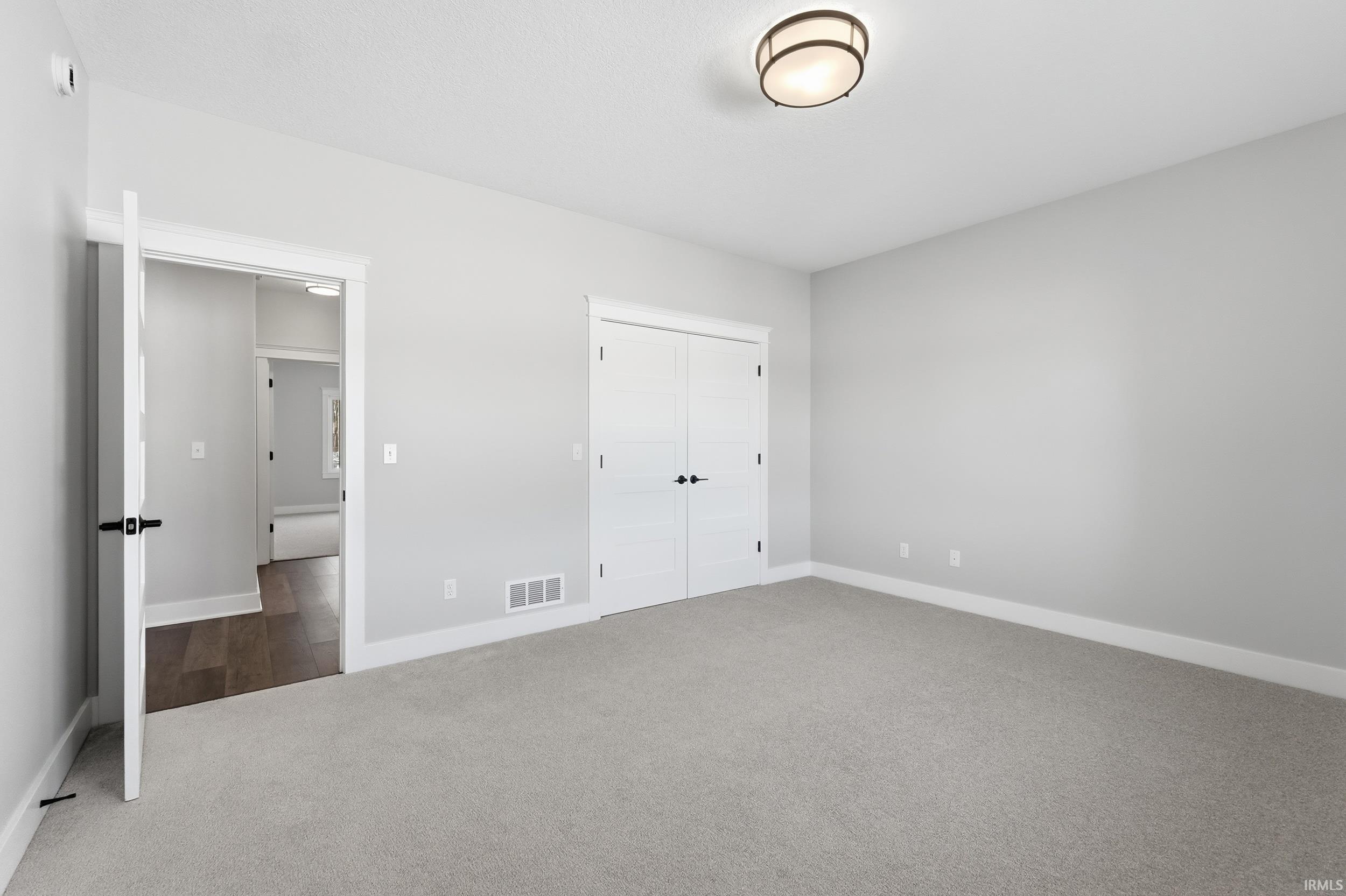 Unfurnished bedroom with carpet flooring and a closet