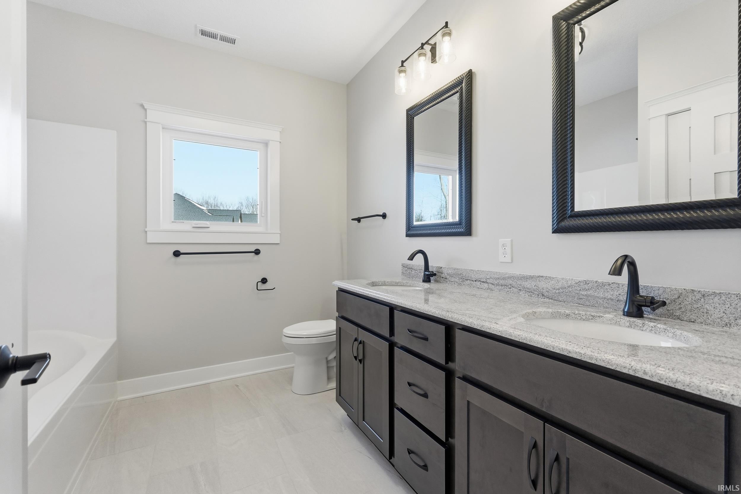 Full bath featuring double vanity and shower / bath combination