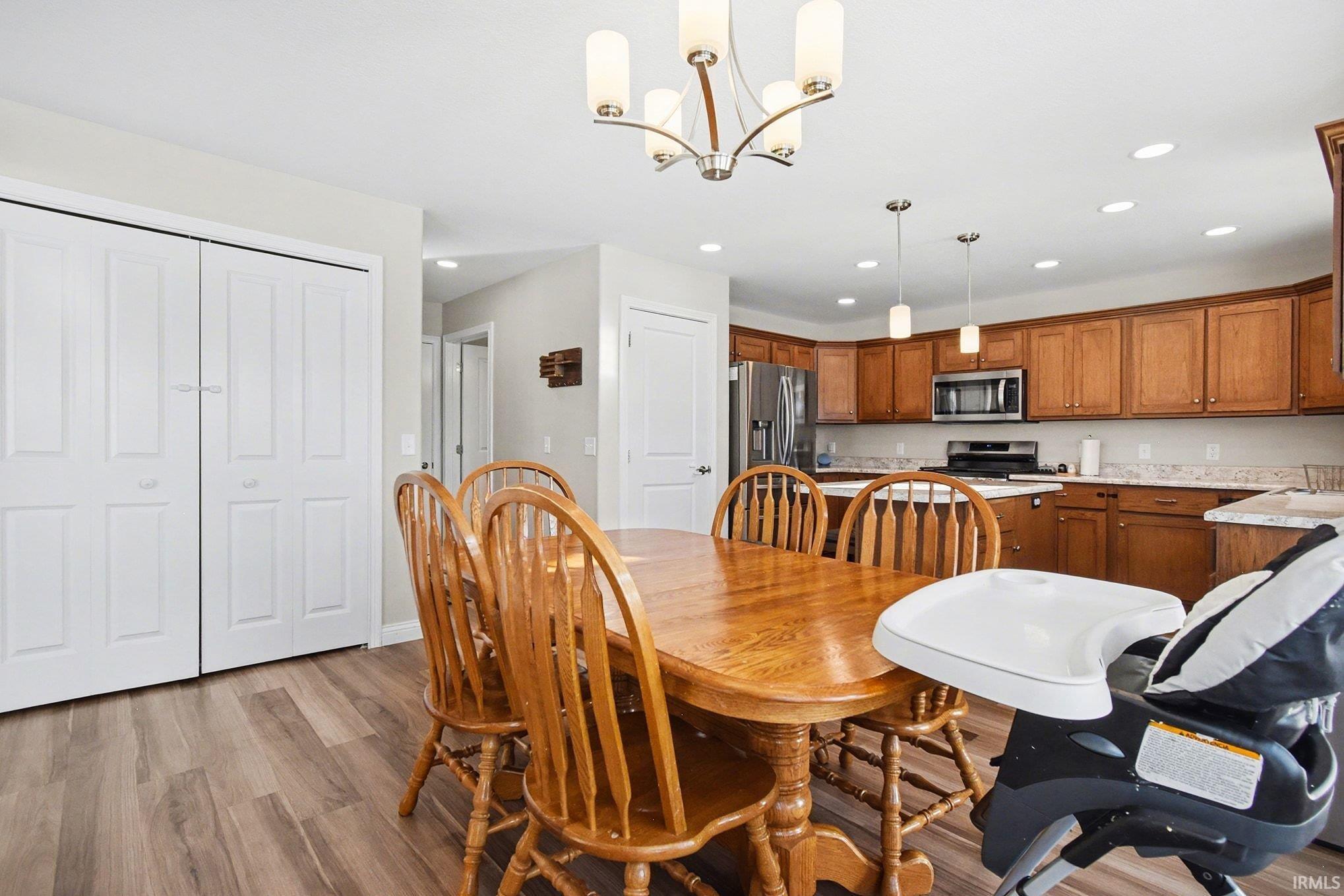 Dining area with recessed lighting, light wood-style flooring, and a chandelier