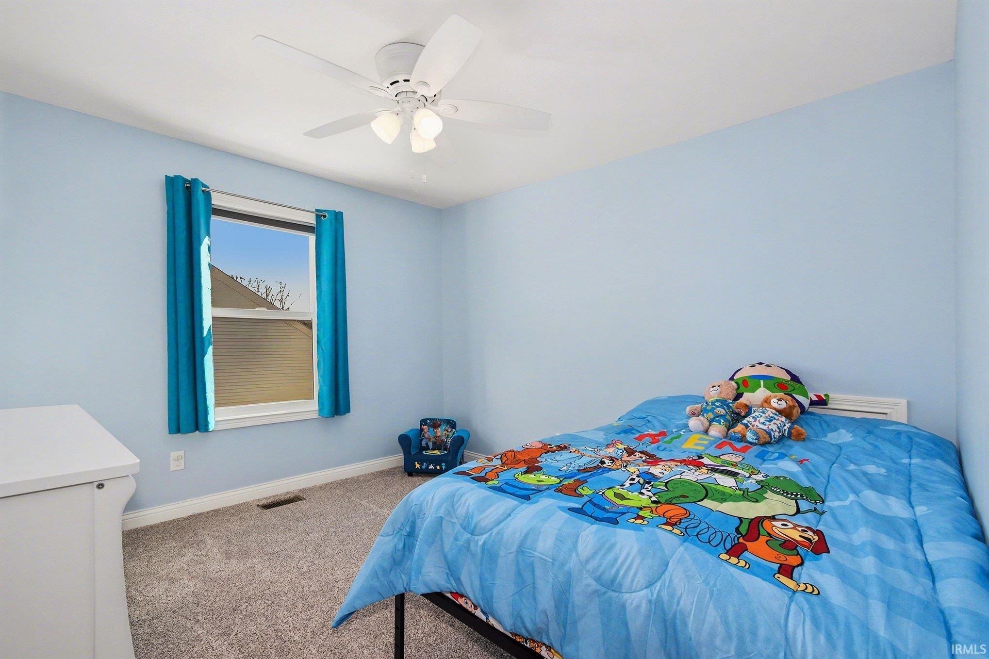 Carpeted bedroom with baseboards and a ceiling fan