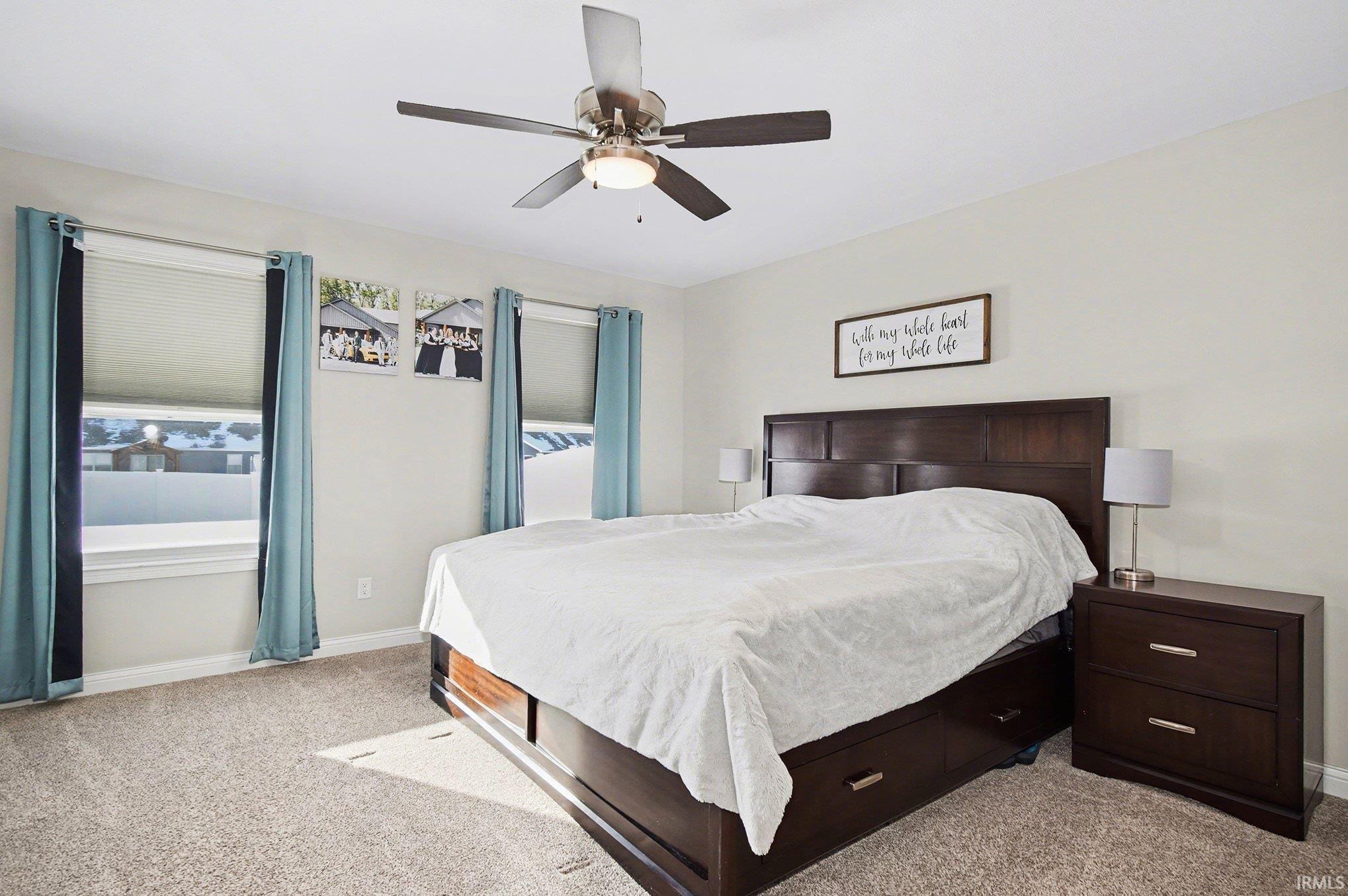 Bedroom featuring light colored carpet and a ceiling fan