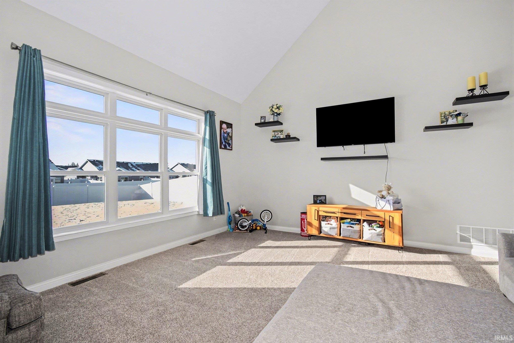 Game room with light carpet and high vaulted ceiling