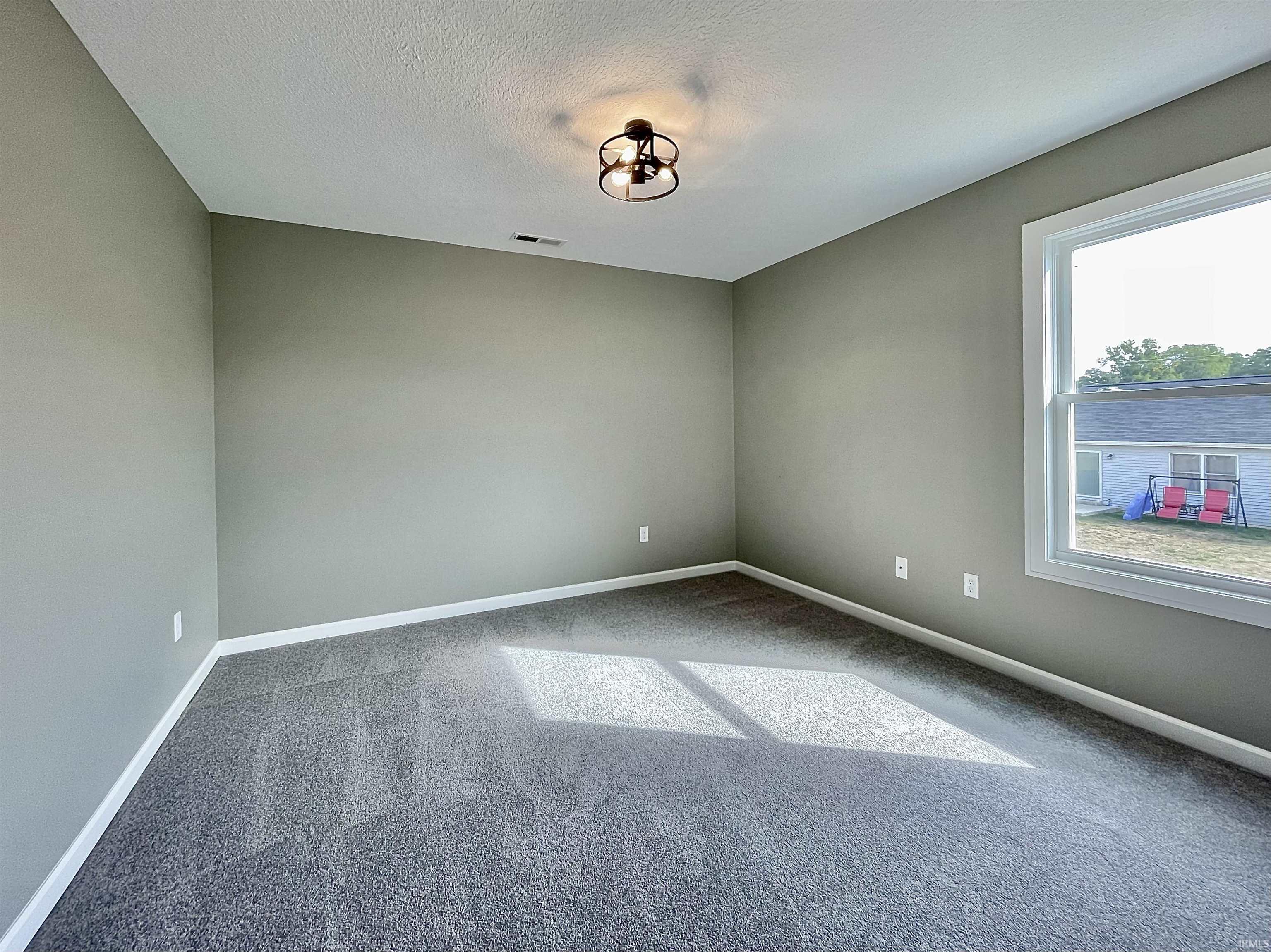 Carpeted spare room with baseboards and a textured ceiling