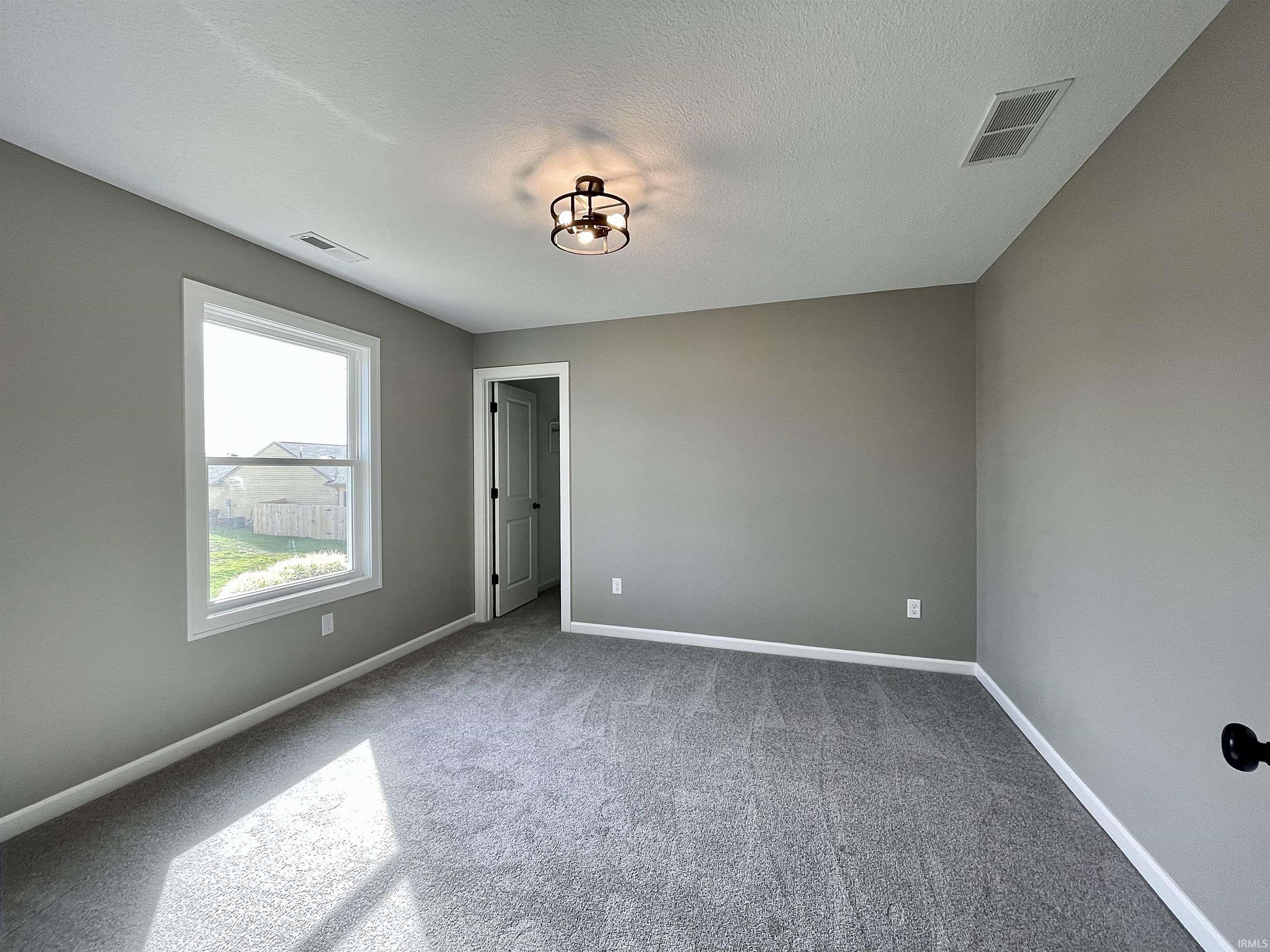 Spare room featuring light carpet and a textured ceiling