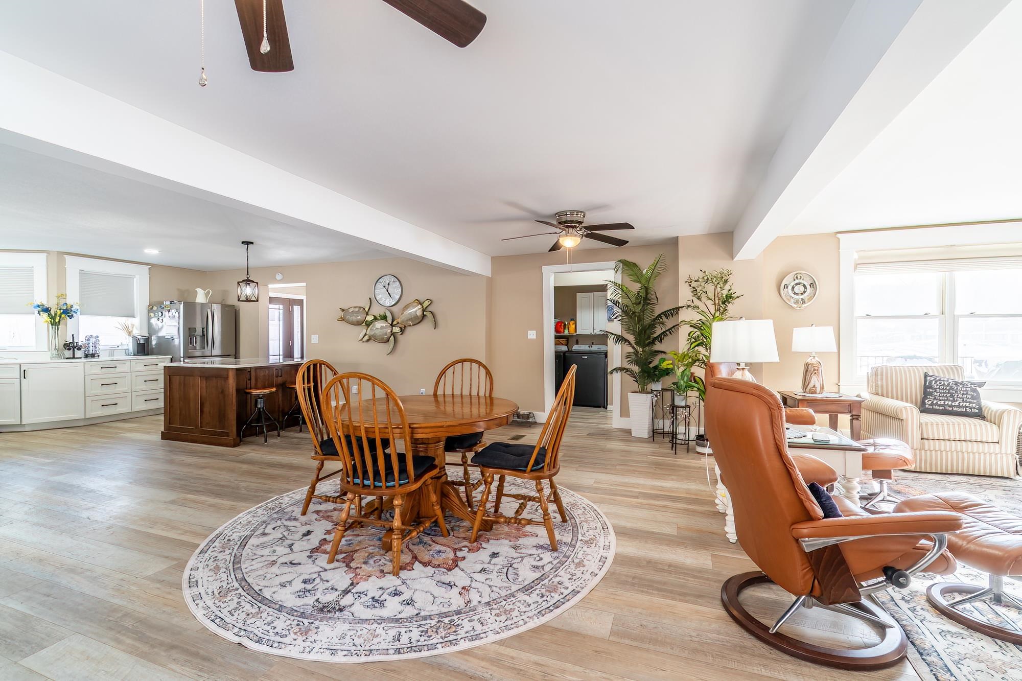 Dining area featuring healthy amount of natural light, ceiling fan, light wood-style floors, and beamed ceiling