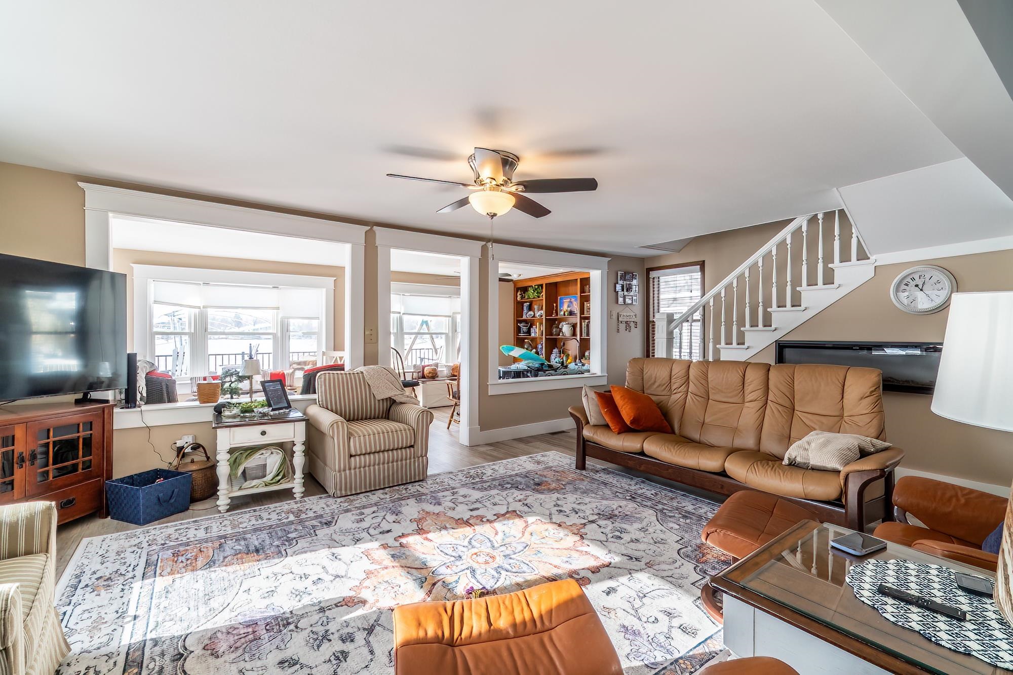 Living room with stairway, wood finished floors, and ceiling fan