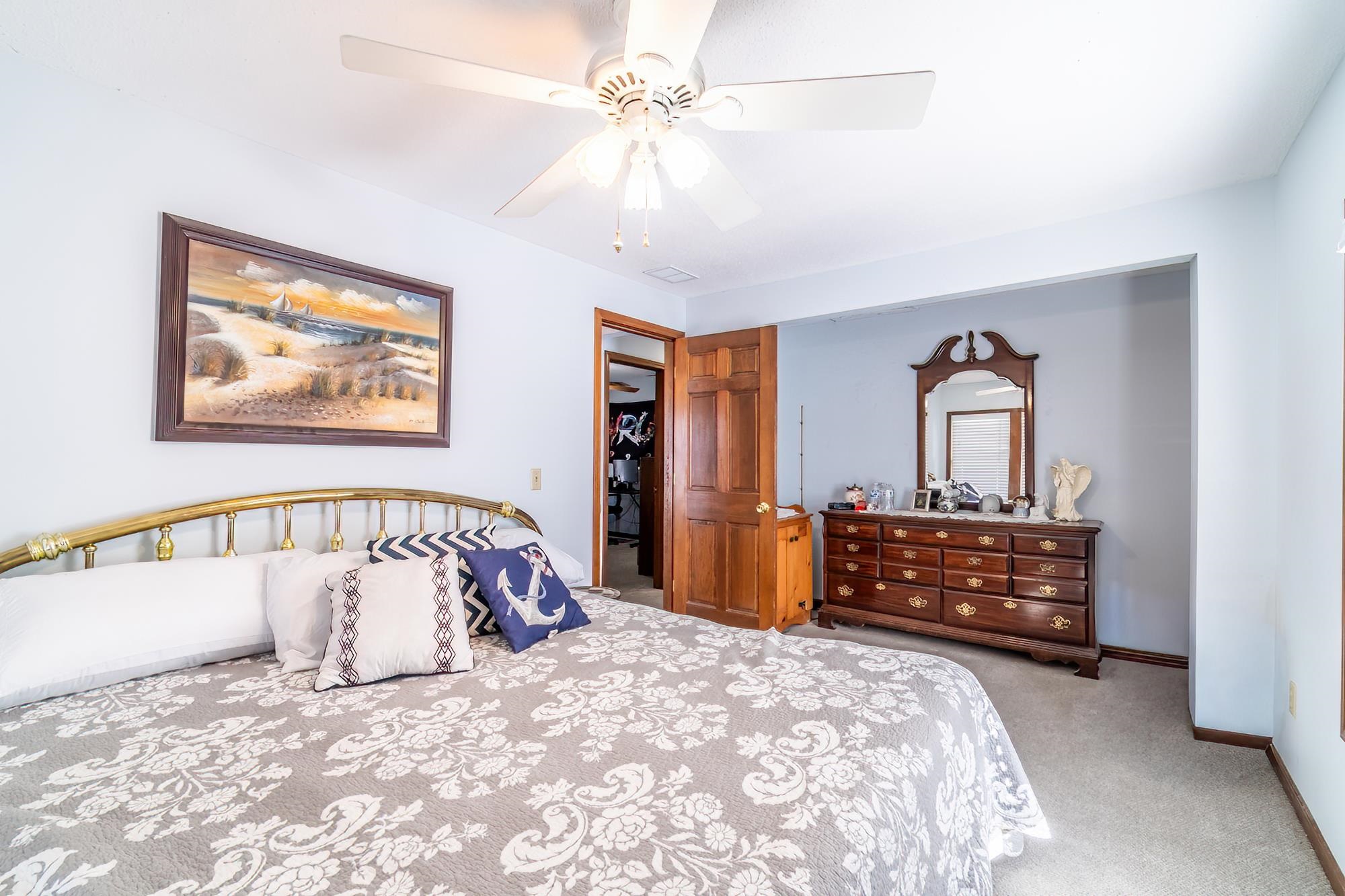Bedroom with light colored carpet and ceiling fan