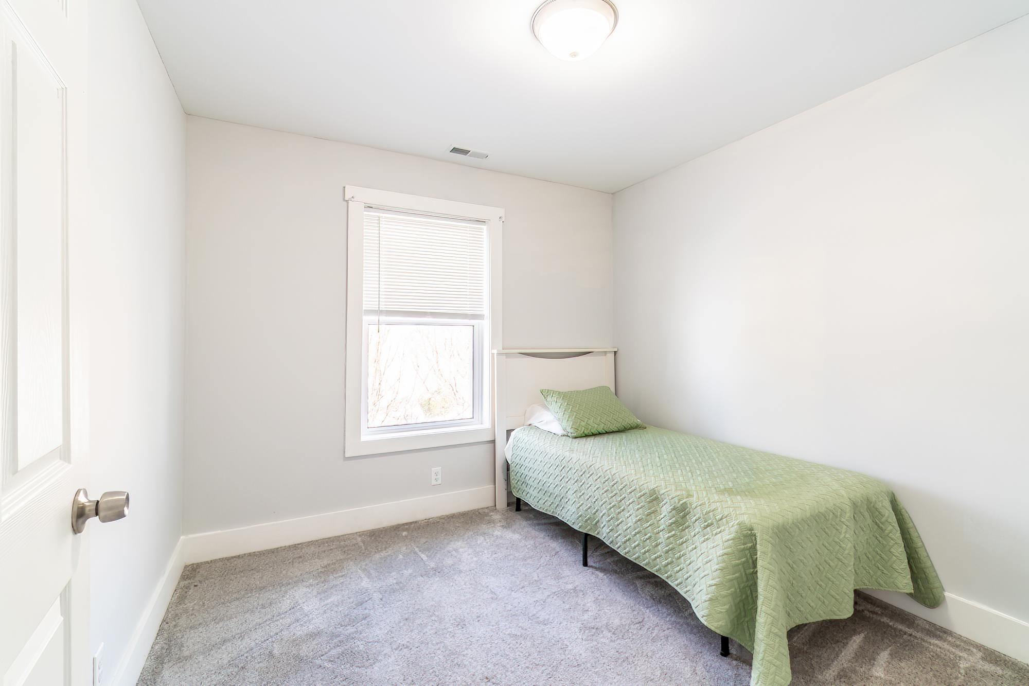 Bedroom featuring carpet and baseboards