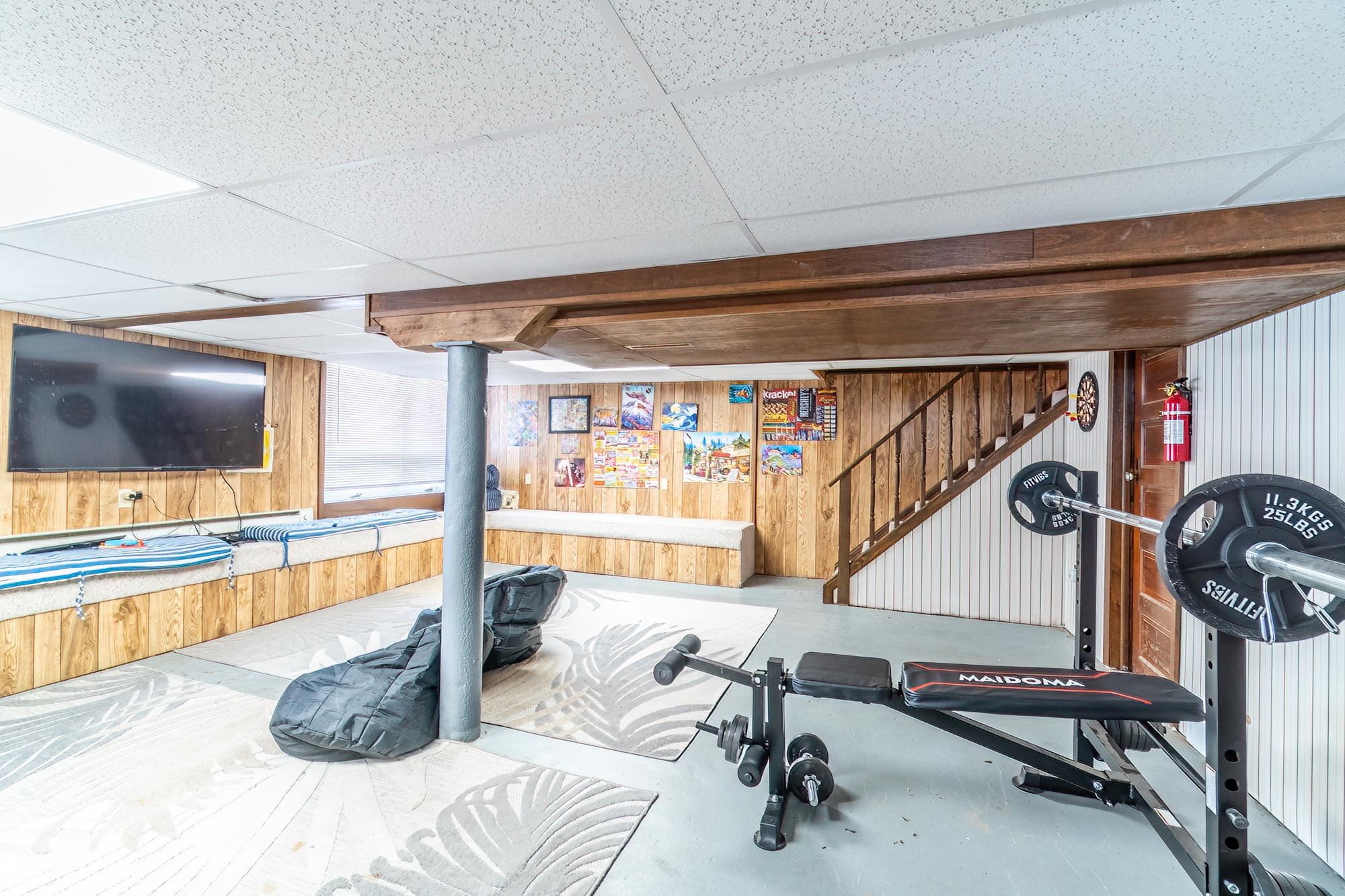 Workout room with wooden walls and a drop ceiling