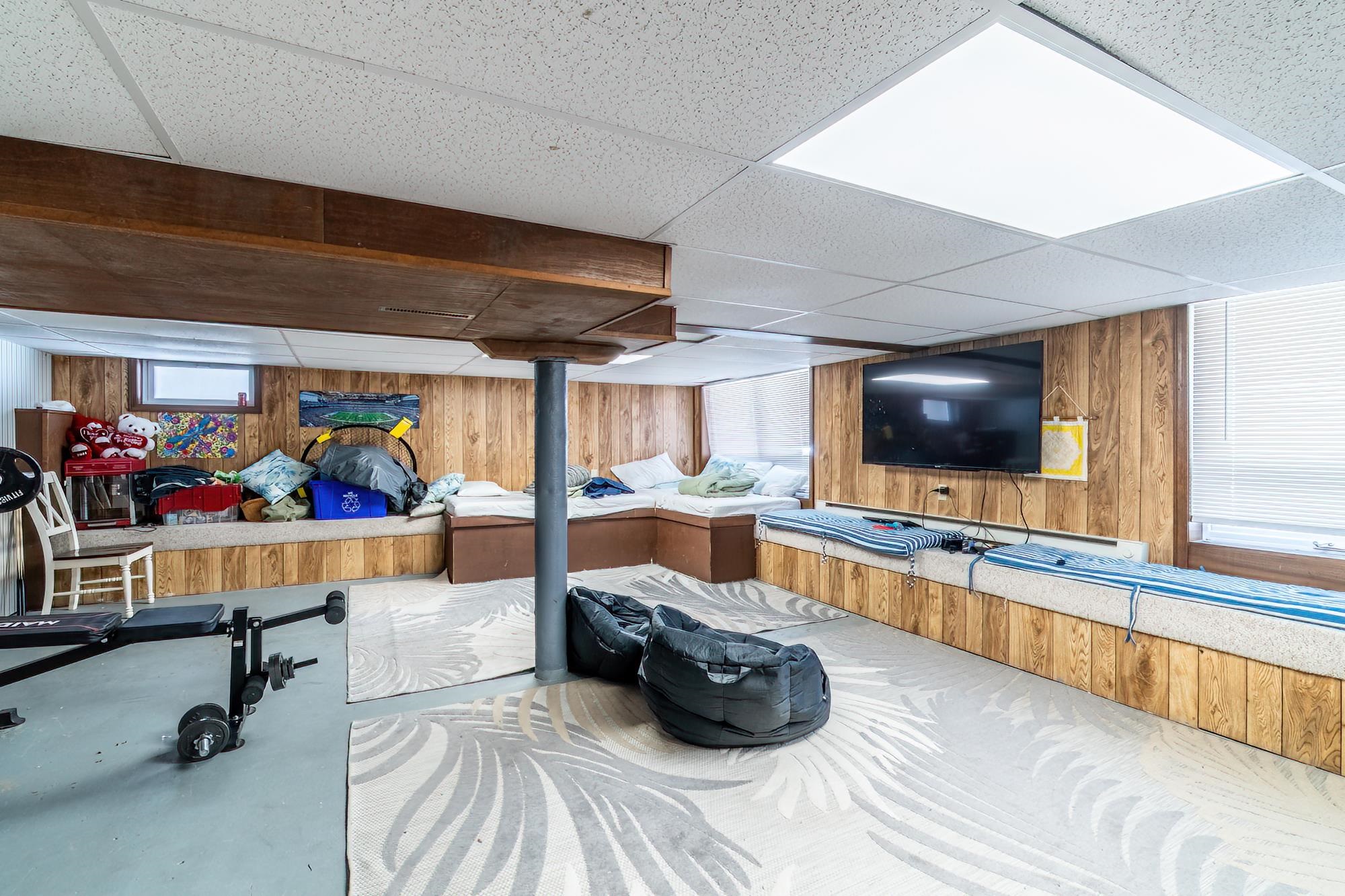 Basement featuring wood walls and a drop ceiling