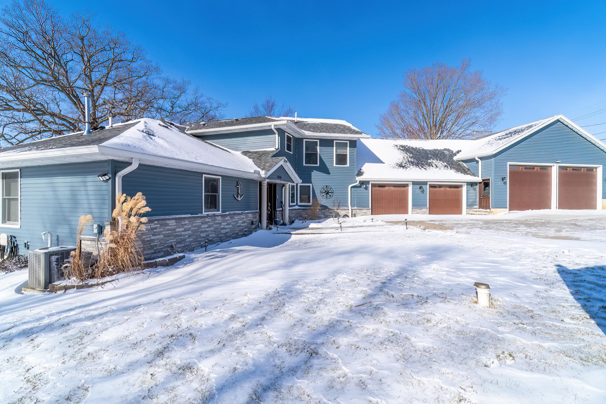 View of front of home featuring stone siding and a garage