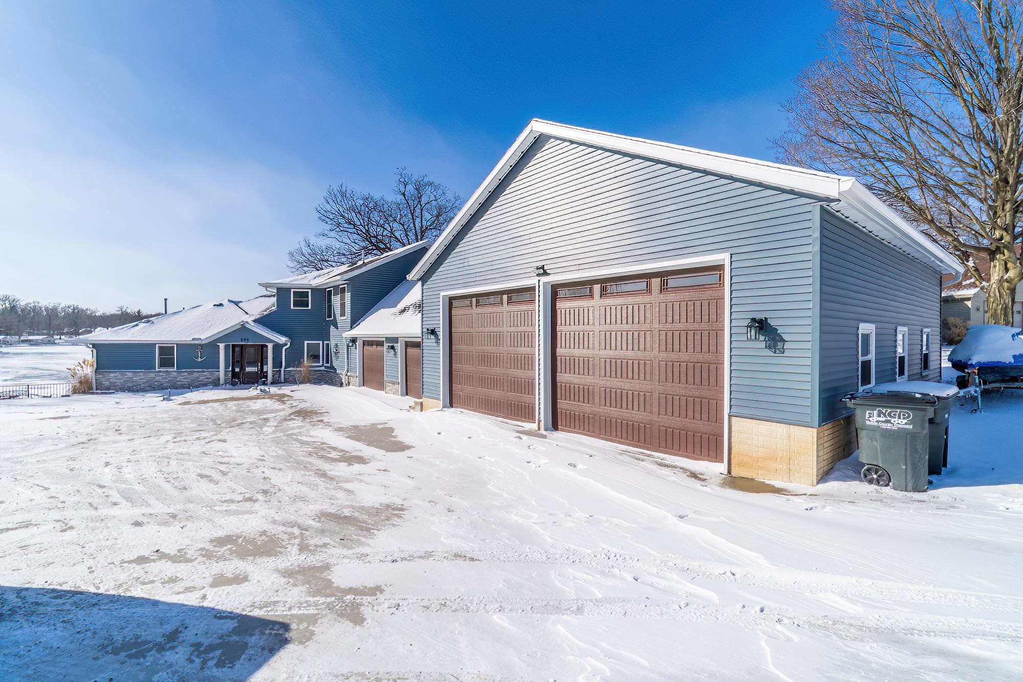 View of snow covered exterior with a garage