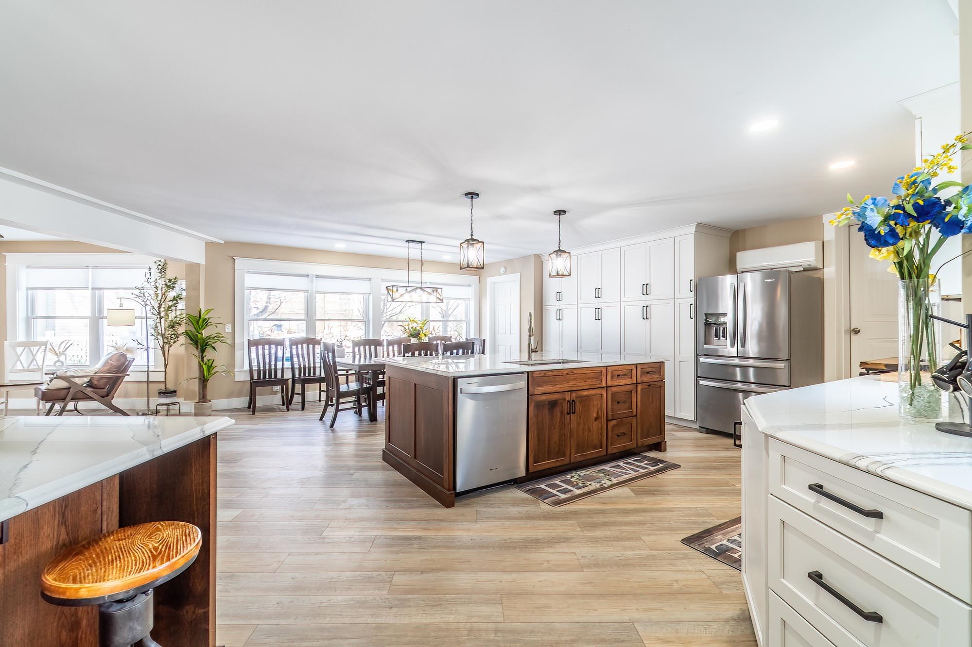Kitchen with white cabinetry, appliances with stainless steel finishes, and light stone countertops