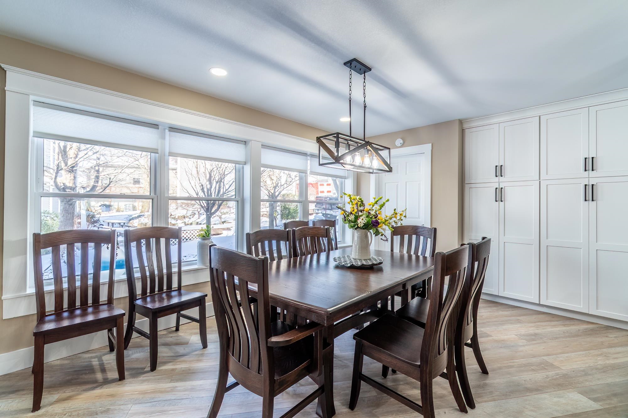 Dining area with light wood finished floors and recessed lighting