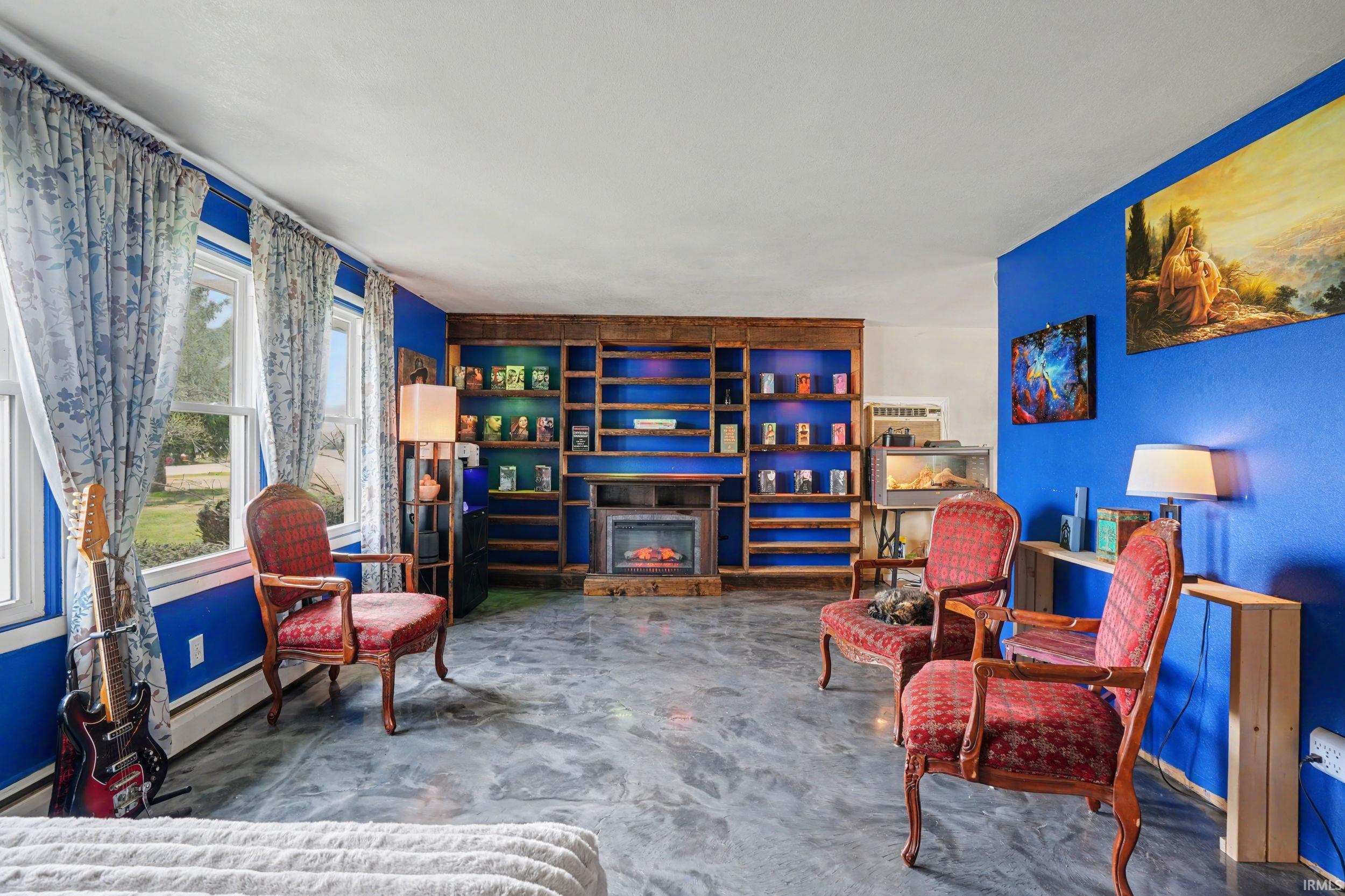 Living area featuring a glass covered fireplace and a baseboard heating unit