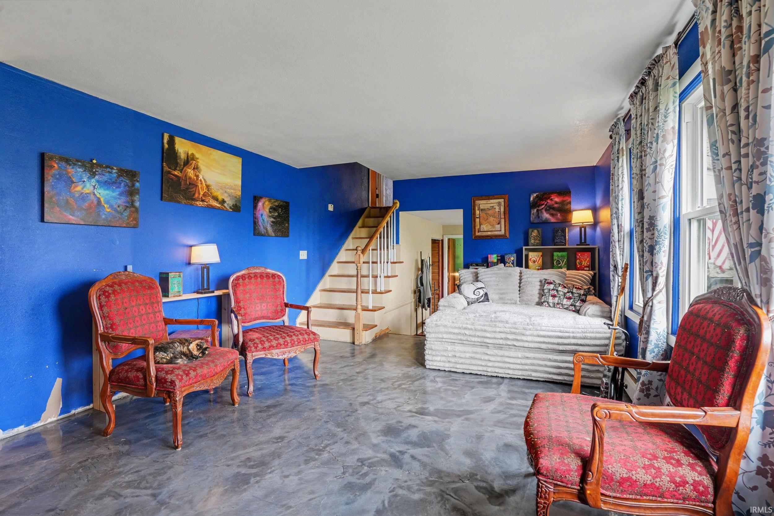 Sitting room with concrete floors and stairs