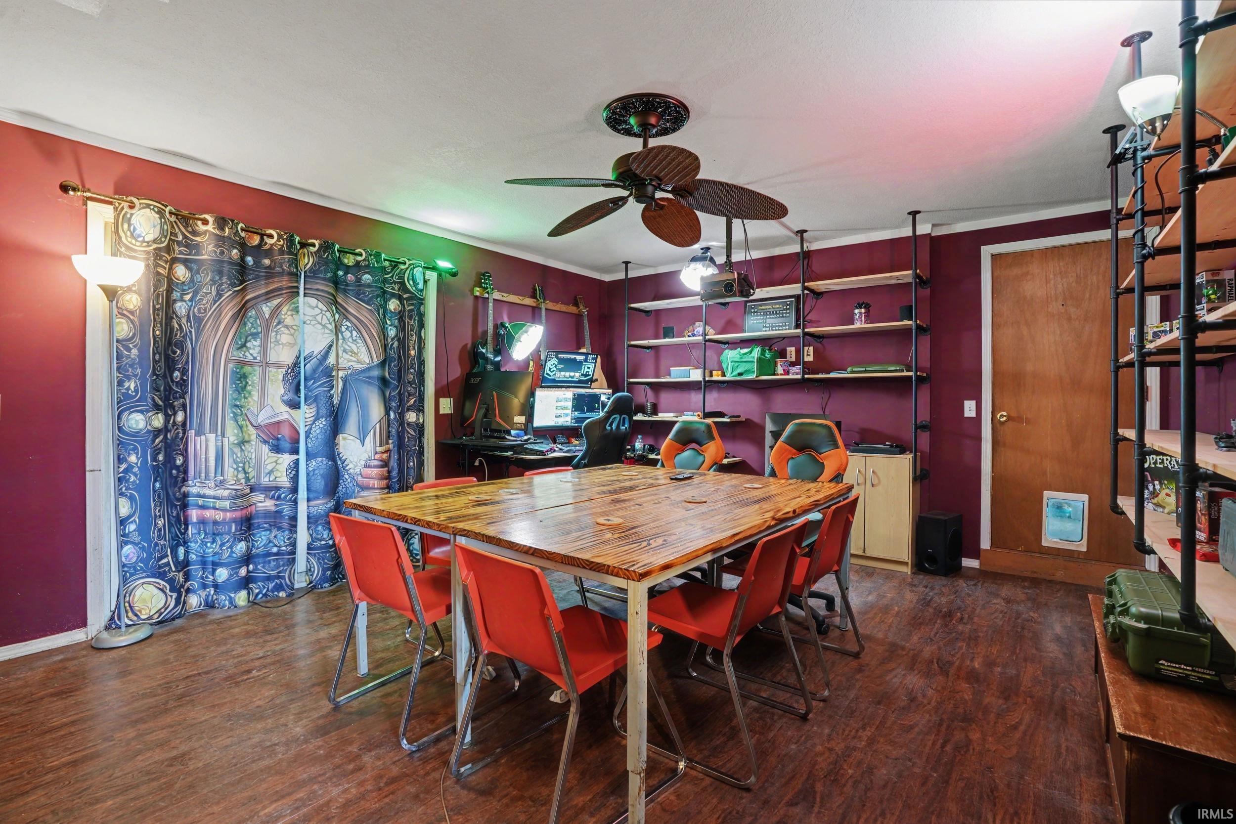 Family space with a ceiling fan and dark wood-type flooring