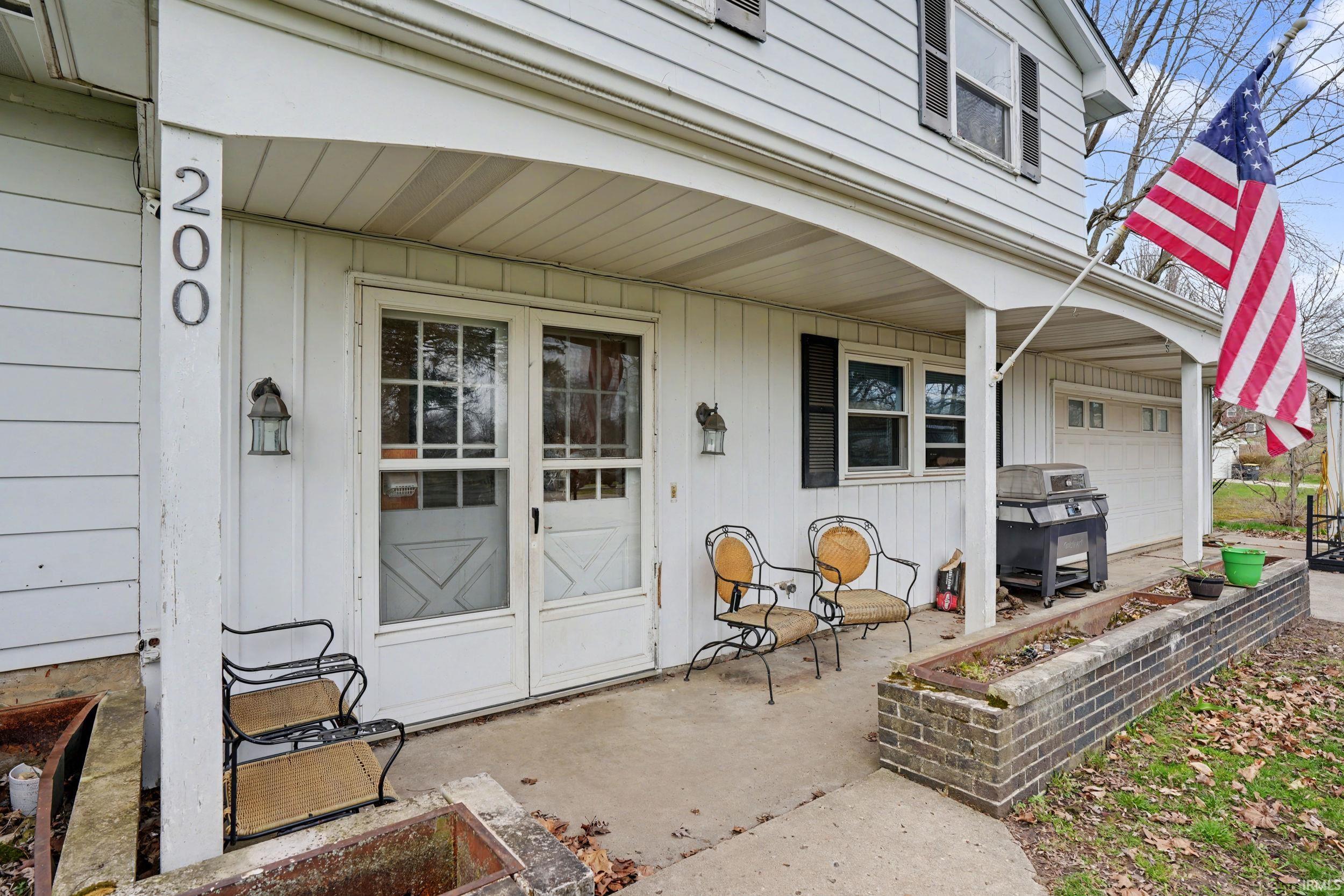 Doorway to property with a porch and an attached garage