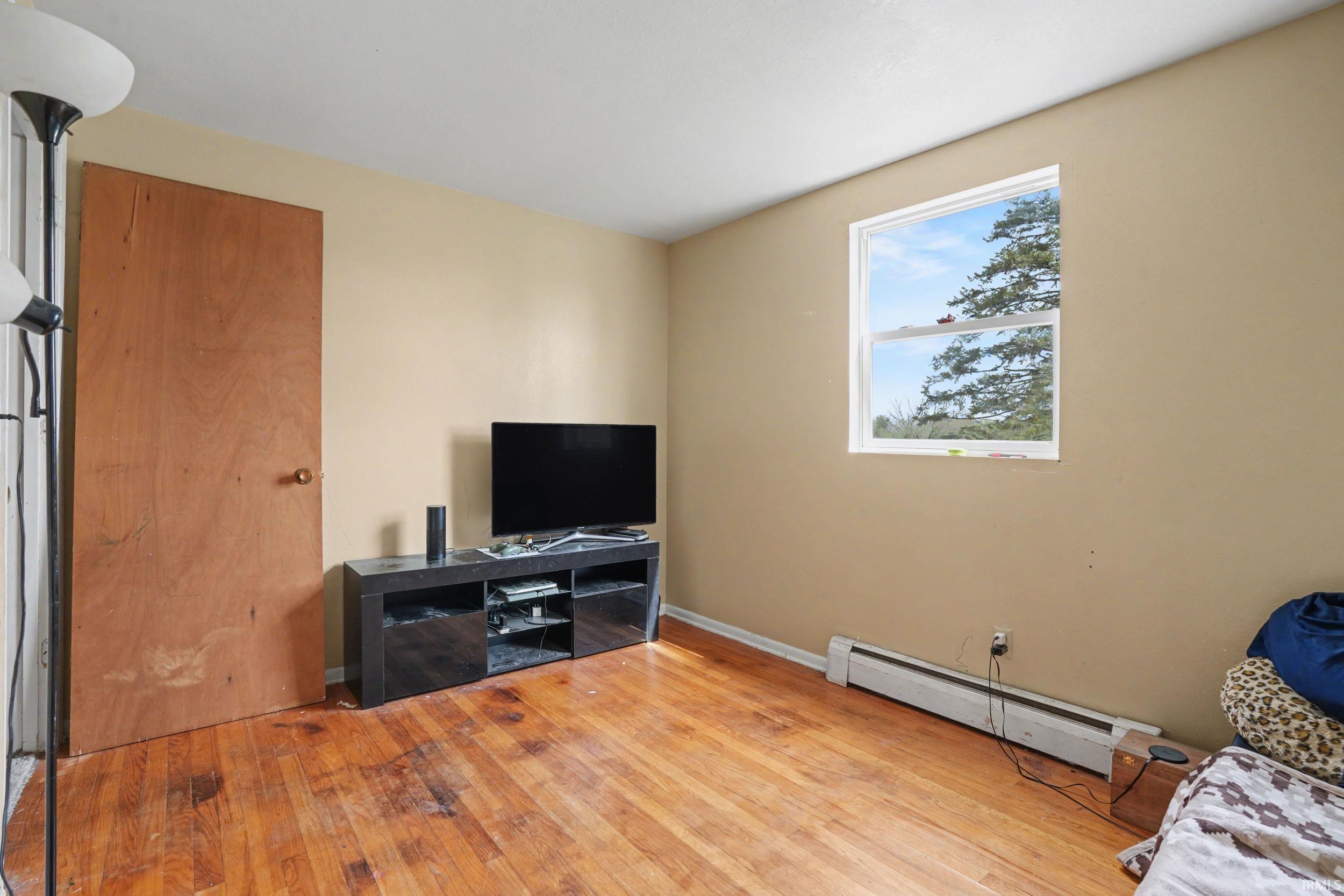Living room with a baseboard radiator and light wood finished floors