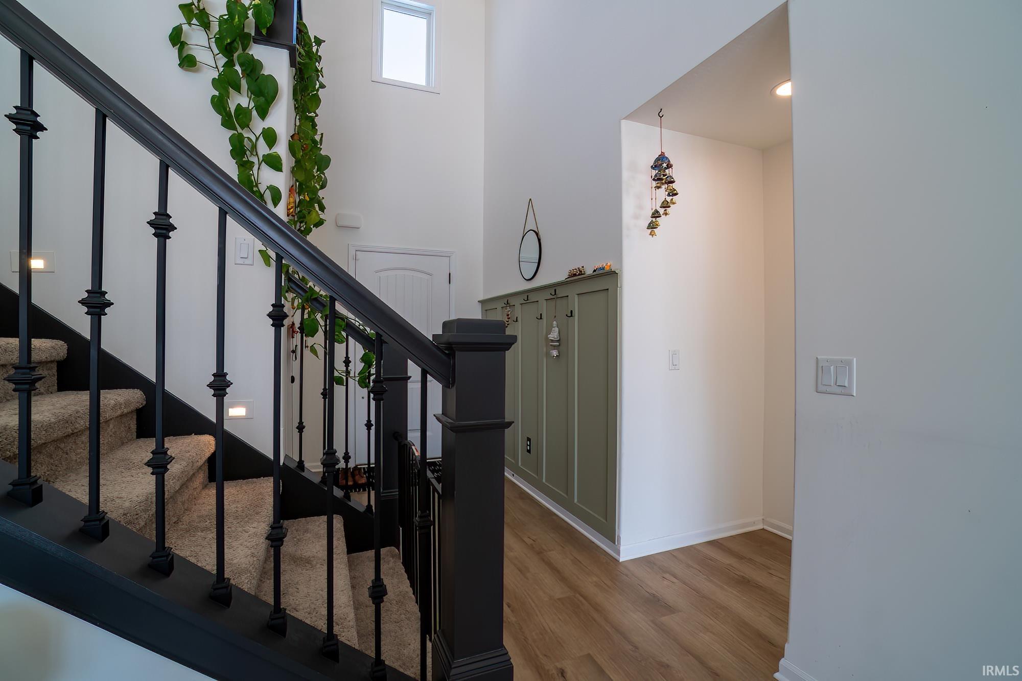 Stairs featuring wood finished floors and a high ceiling