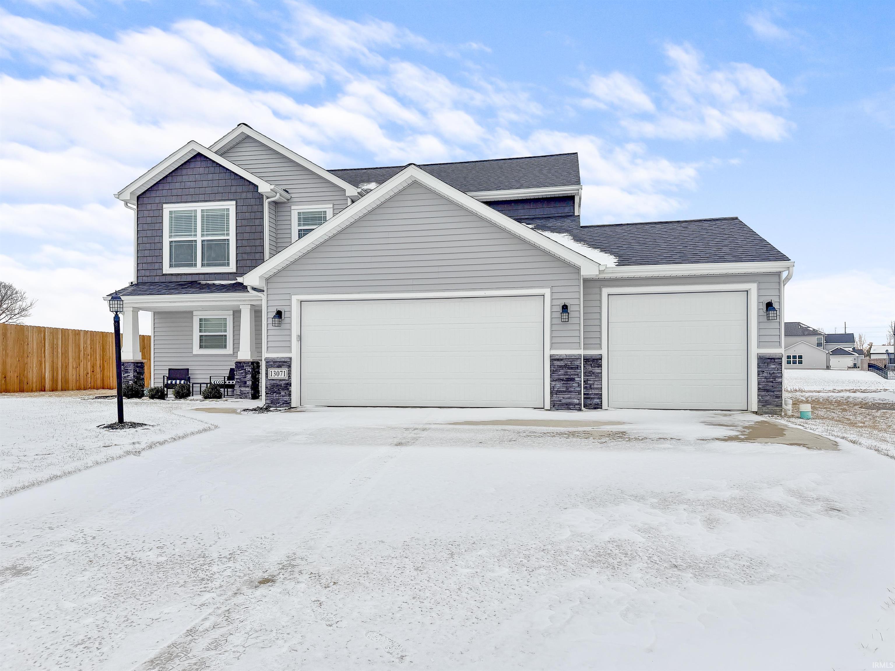 Craftsman inspired home featuring stone siding, an attached garage, a shingled roof, and driveway