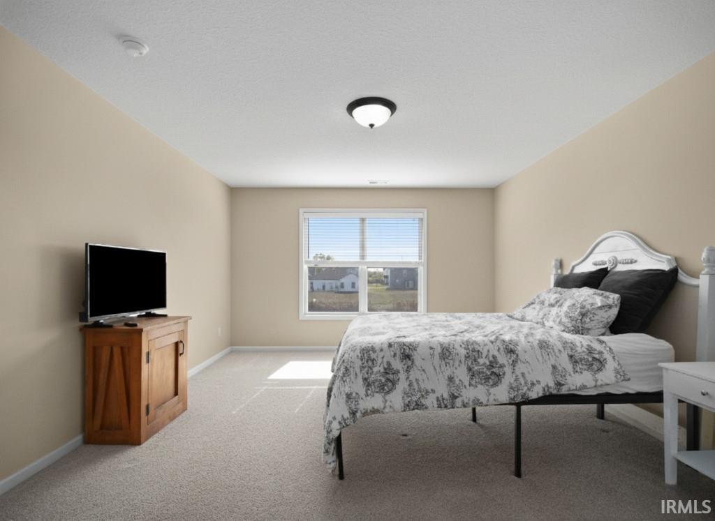 Bedroom featuring light colored carpet and baseboards