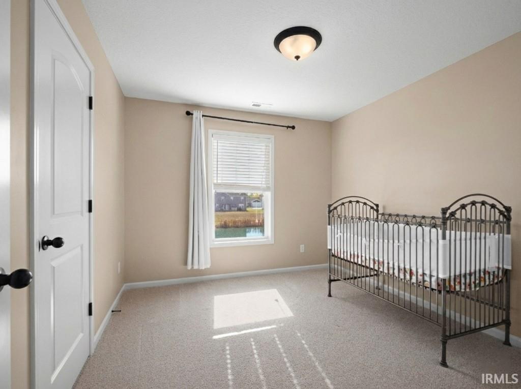 Unfurnished bedroom featuring light colored carpet and baseboards
