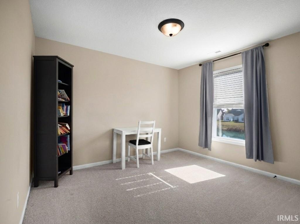 Office with baseboards and light colored carpet