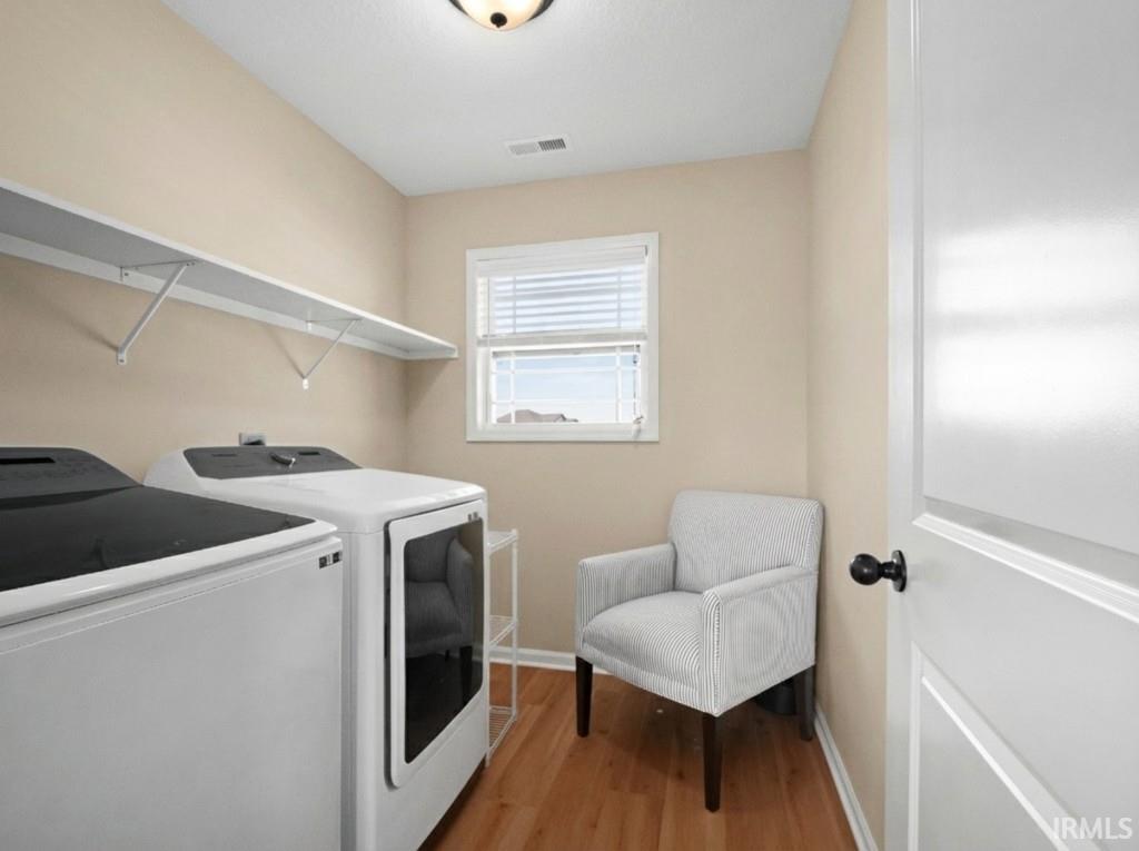 Laundry room featuring light wood-type flooring and separate washer and dryer