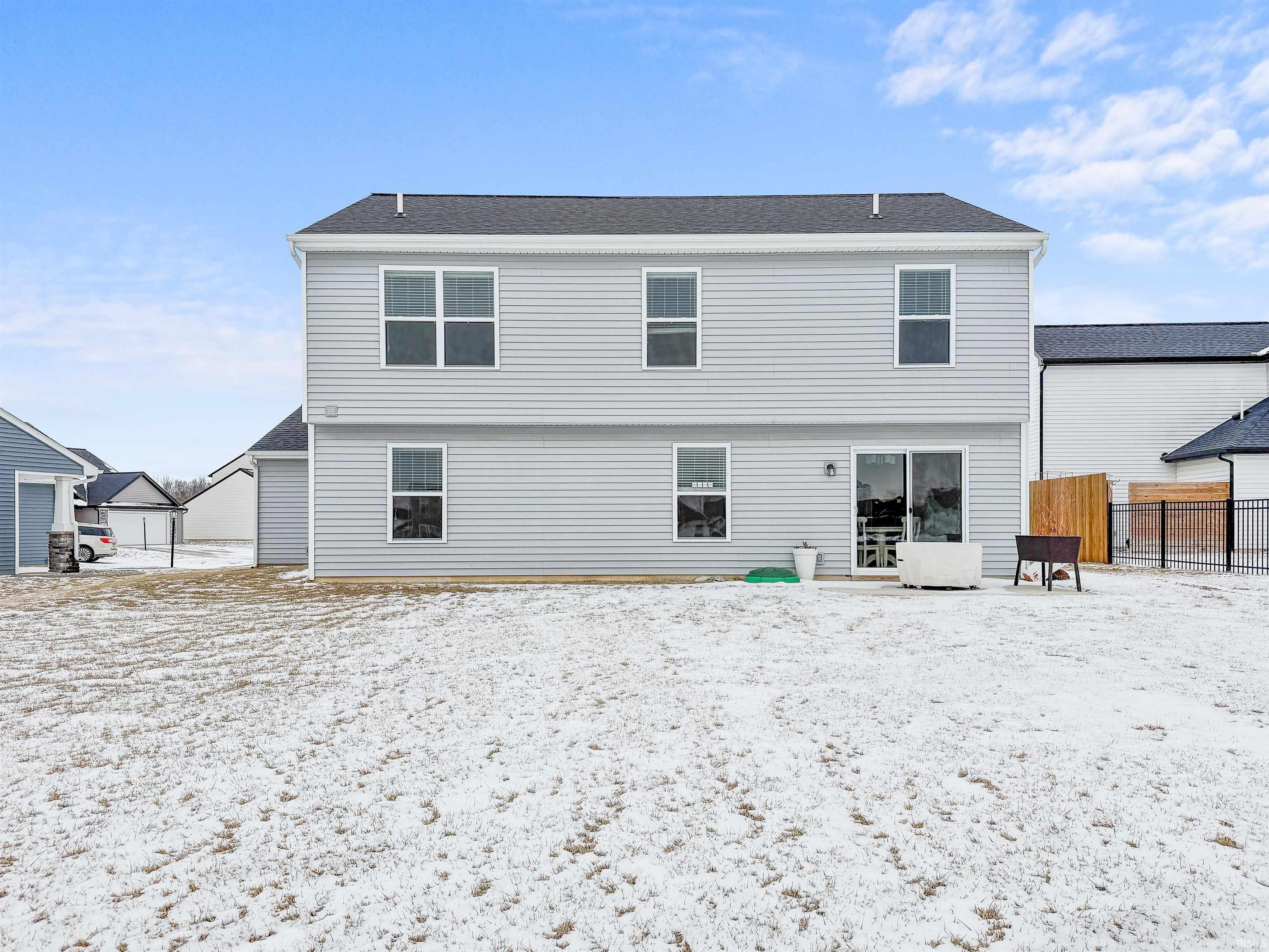 Snow covered rear of property with a patio area