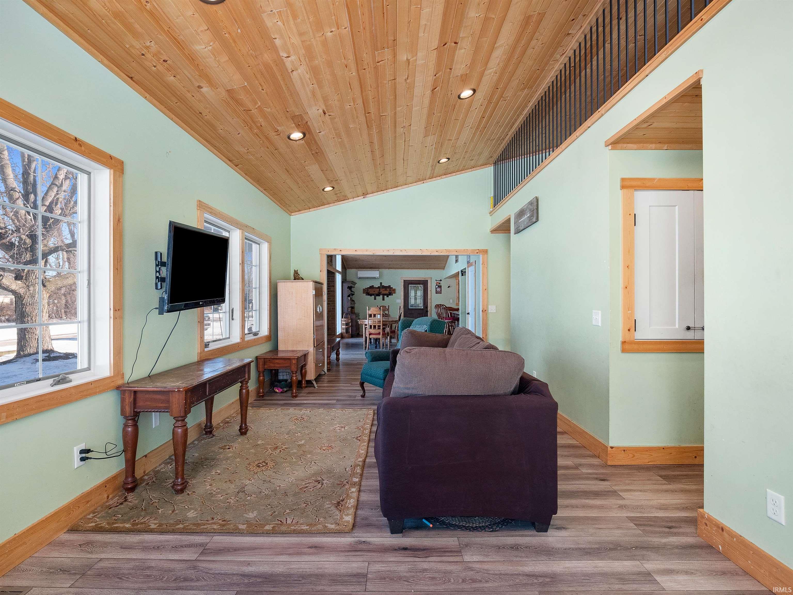 Living area with lofted ceiling, light wood-style floors, wood ceiling, and recessed lighting