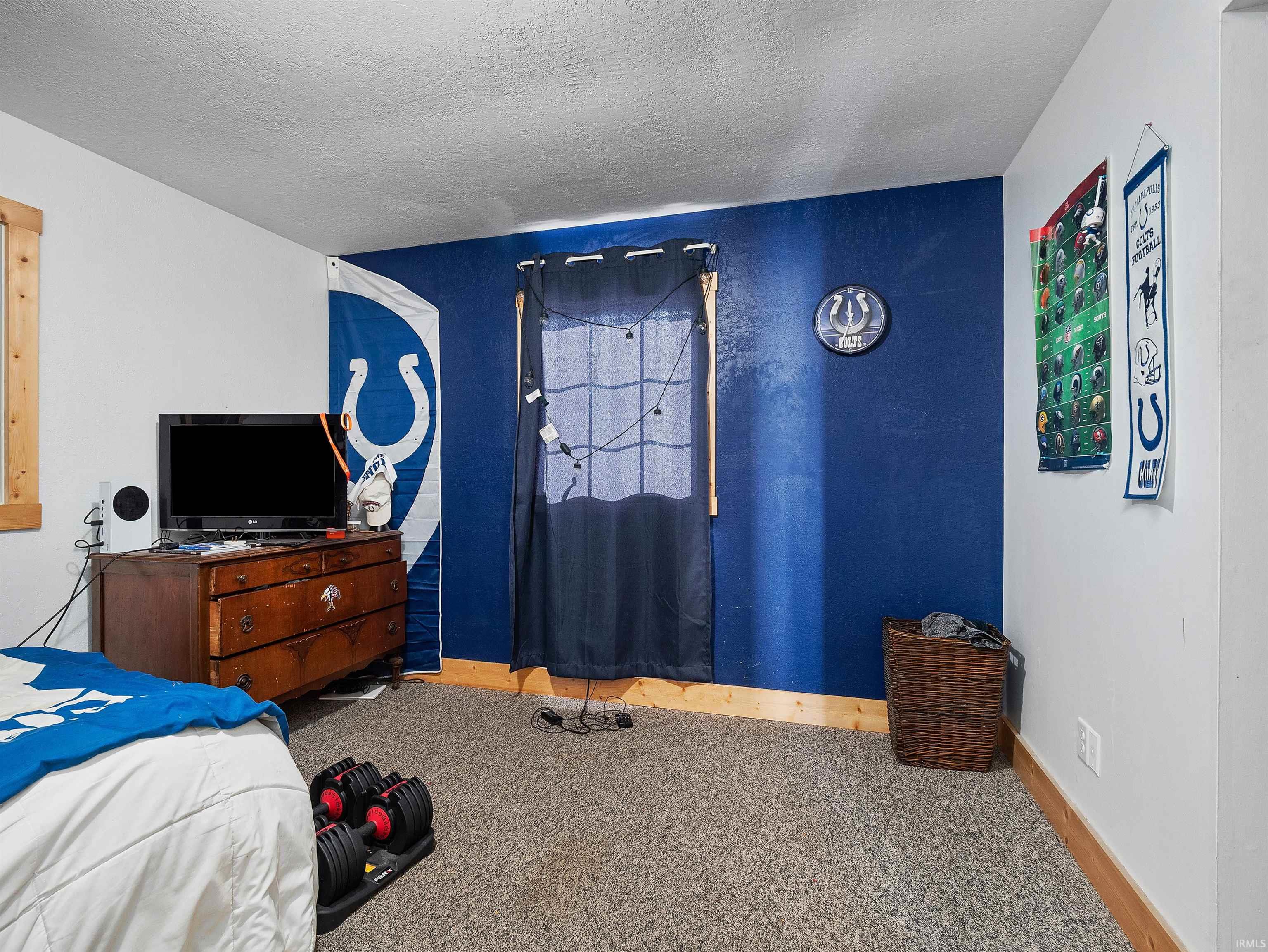 Bedroom with a textured ceiling and carpet floors