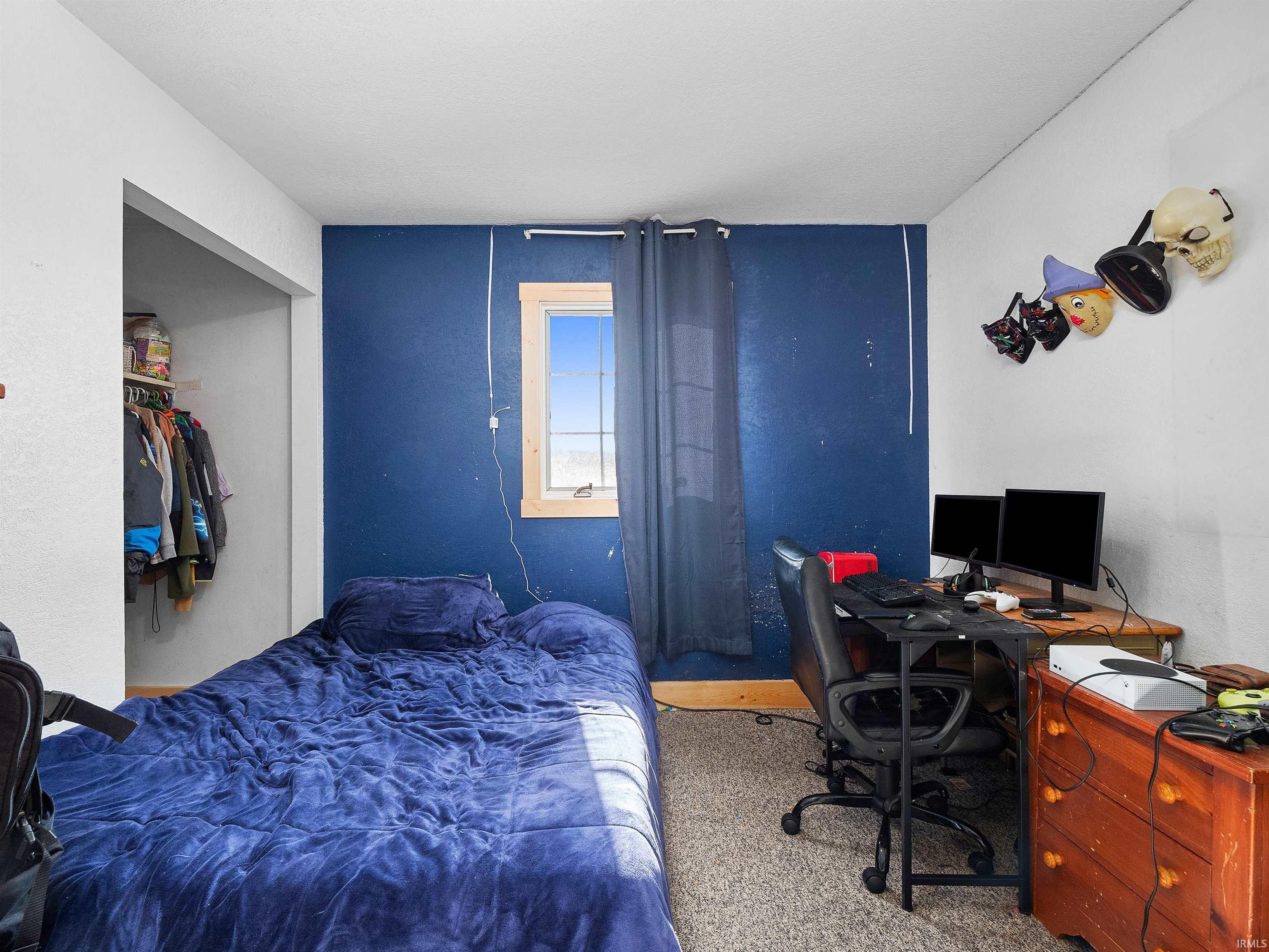 Carpeted bedroom featuring a desk and a closet