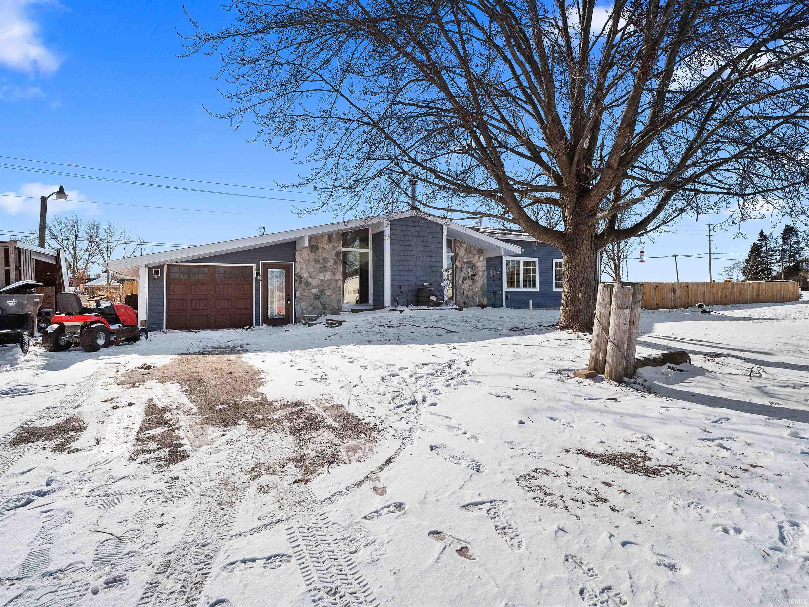 View of front facade with stone siding and a garage