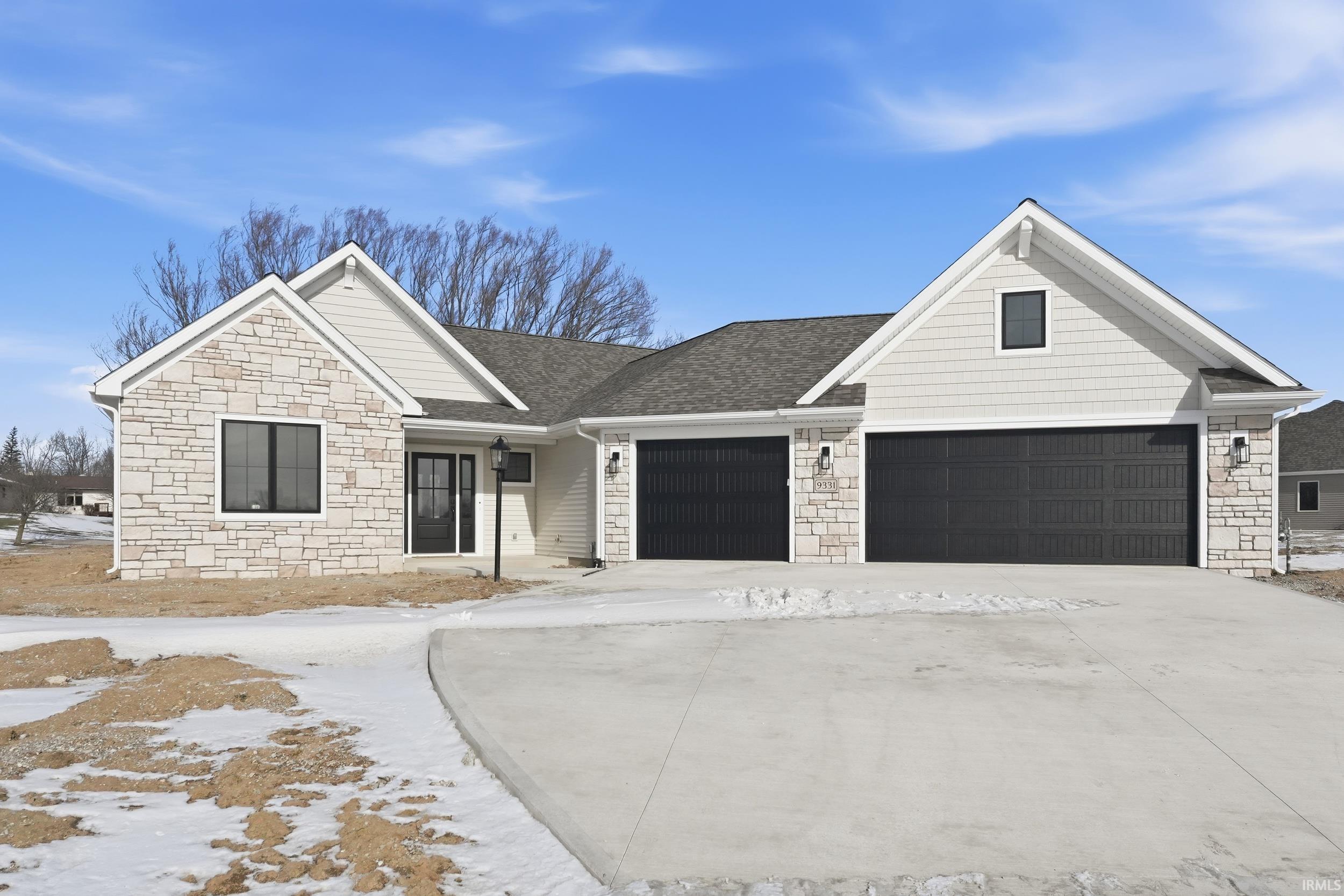 View of front of house with stone siding, concrete driveway, roof with shingles, and a garage