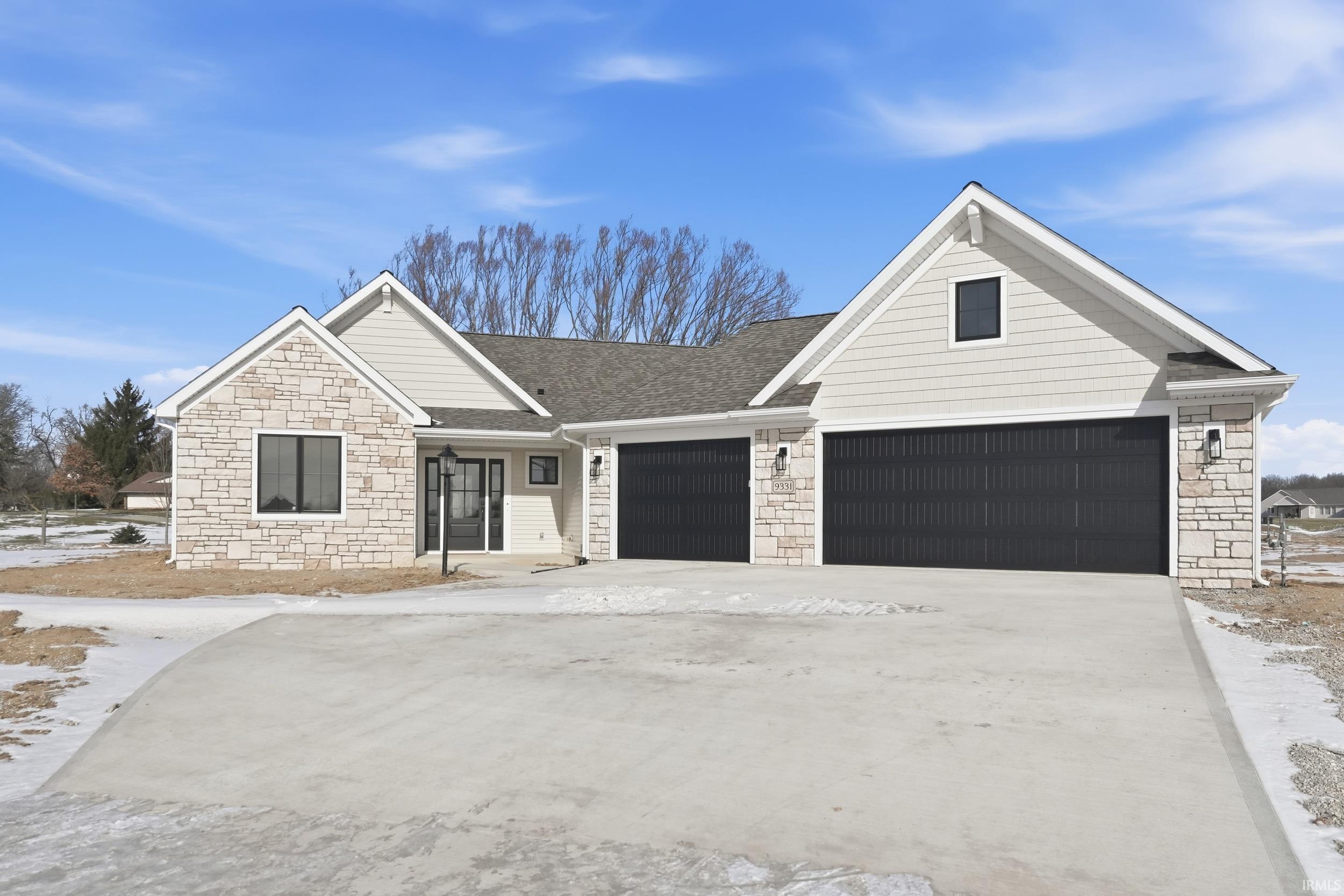 Ranch-style house with stone siding, concrete driveway, a garage, and a shingled roof