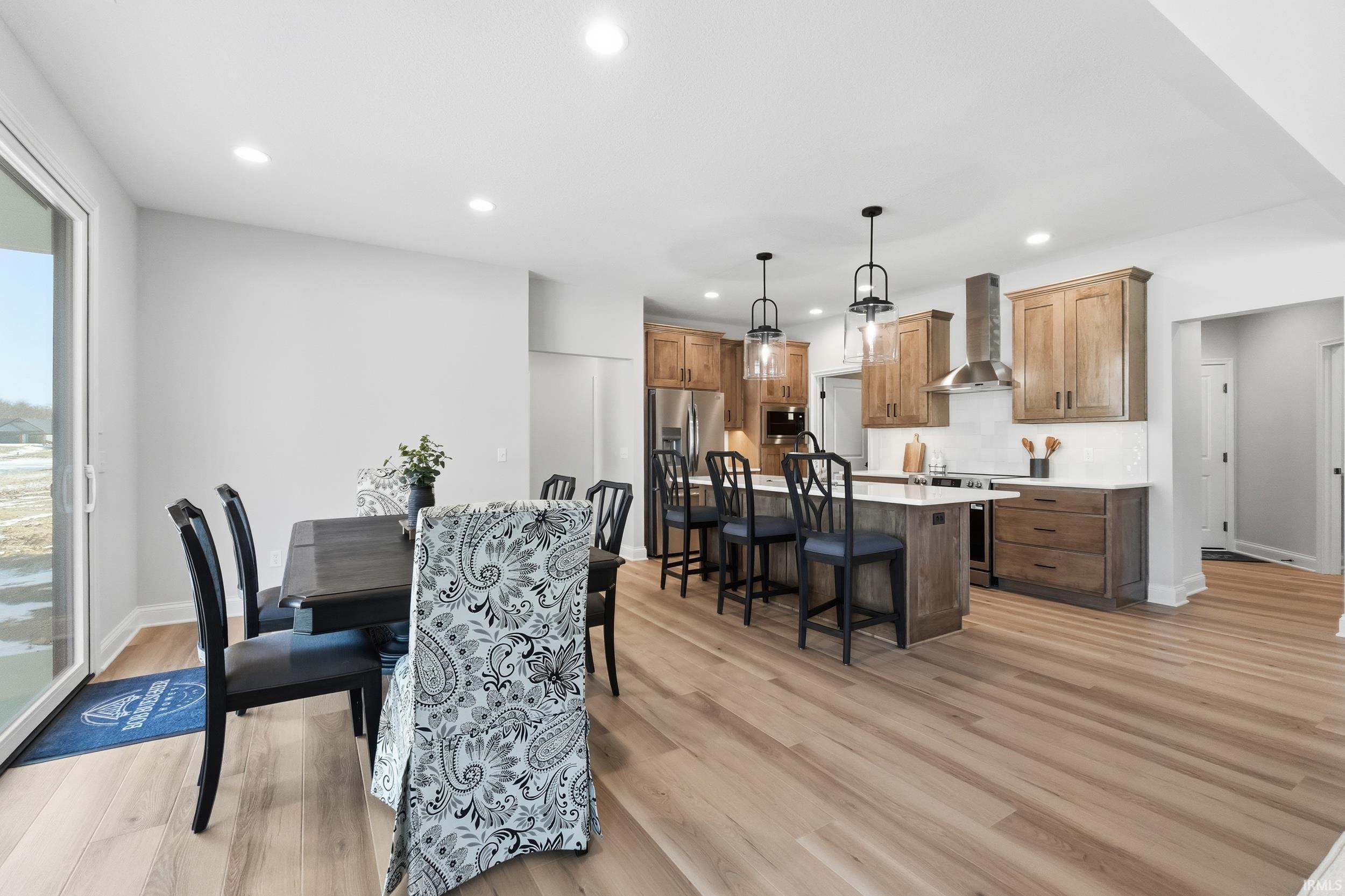 Dining area with recessed lighting and light wood finished floors