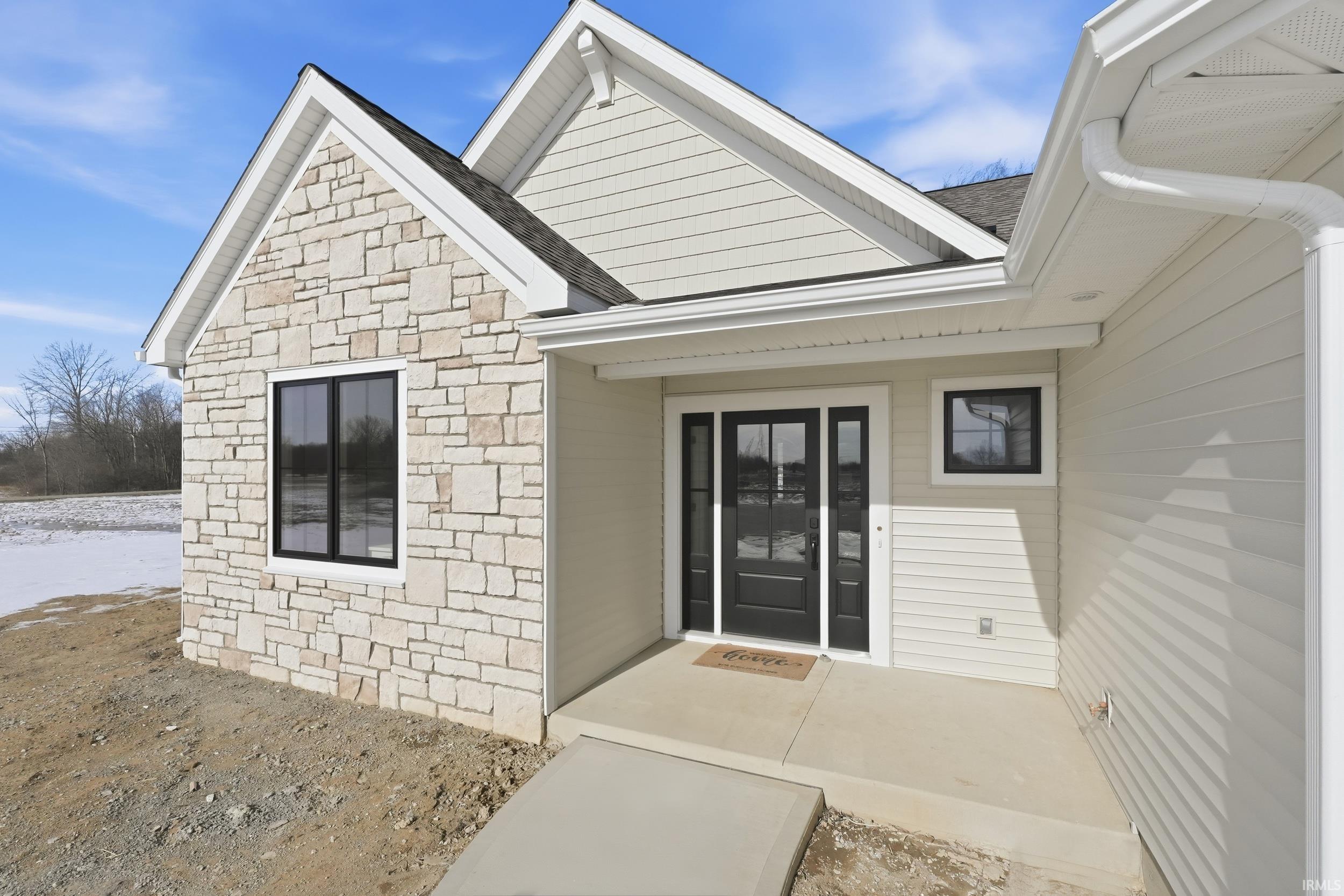 Entrance to property featuring stone siding
